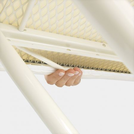 A hand holding a white ironing board. The board has a yellow patterned surface.