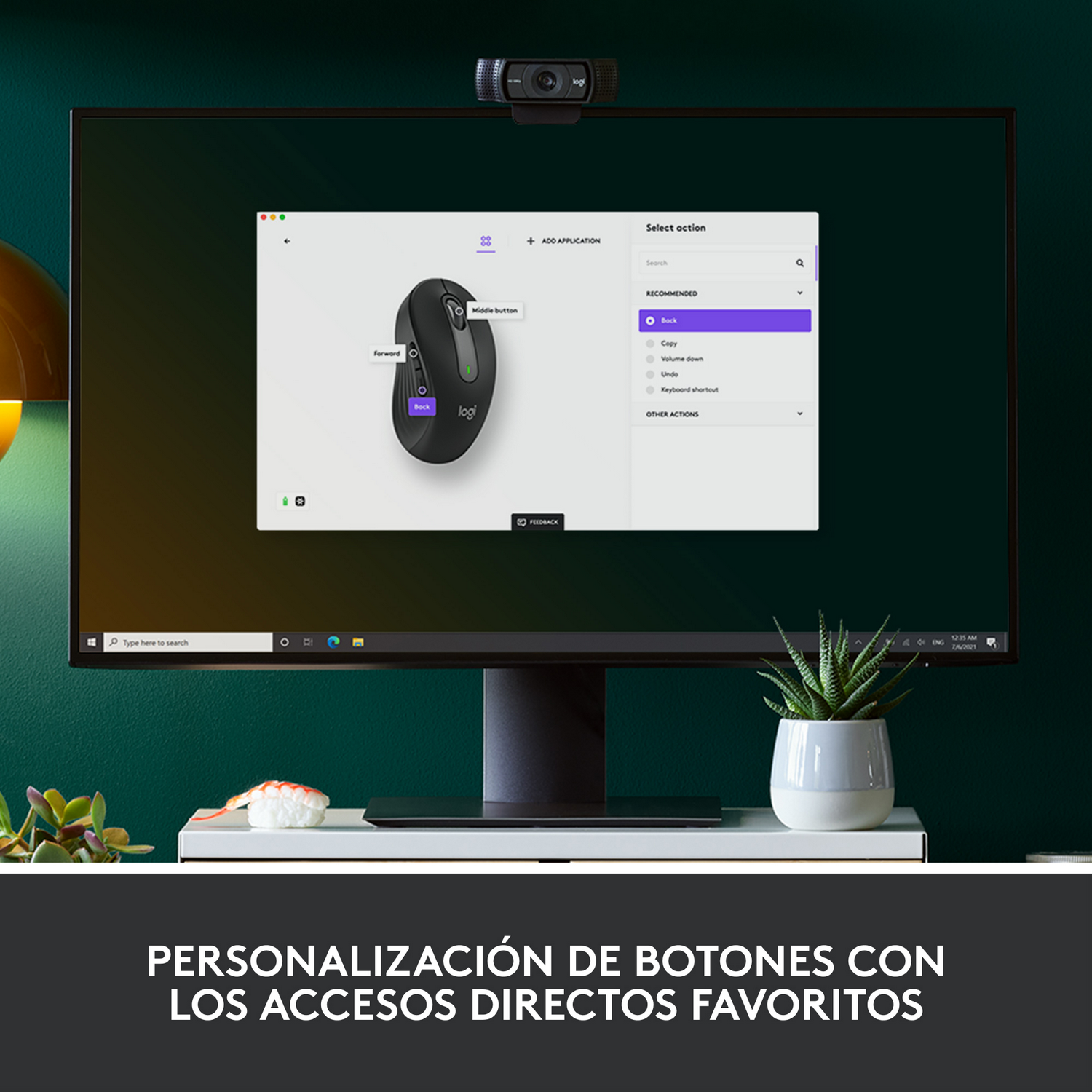 Una pantalla de computadora muestra una interfaz de personalización del mouse, con una cámara web en la parte superior. Una planta pequeña está al lado.