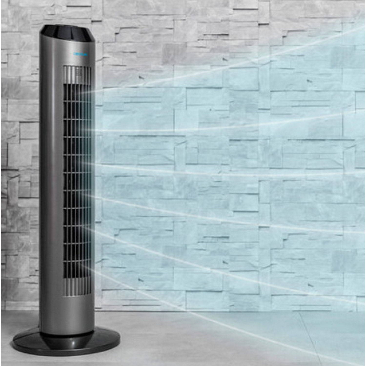 Ventilador de torre alto plateado. Líneas azules indican flujo de aire. Fondo de pared de ladrillo gris.