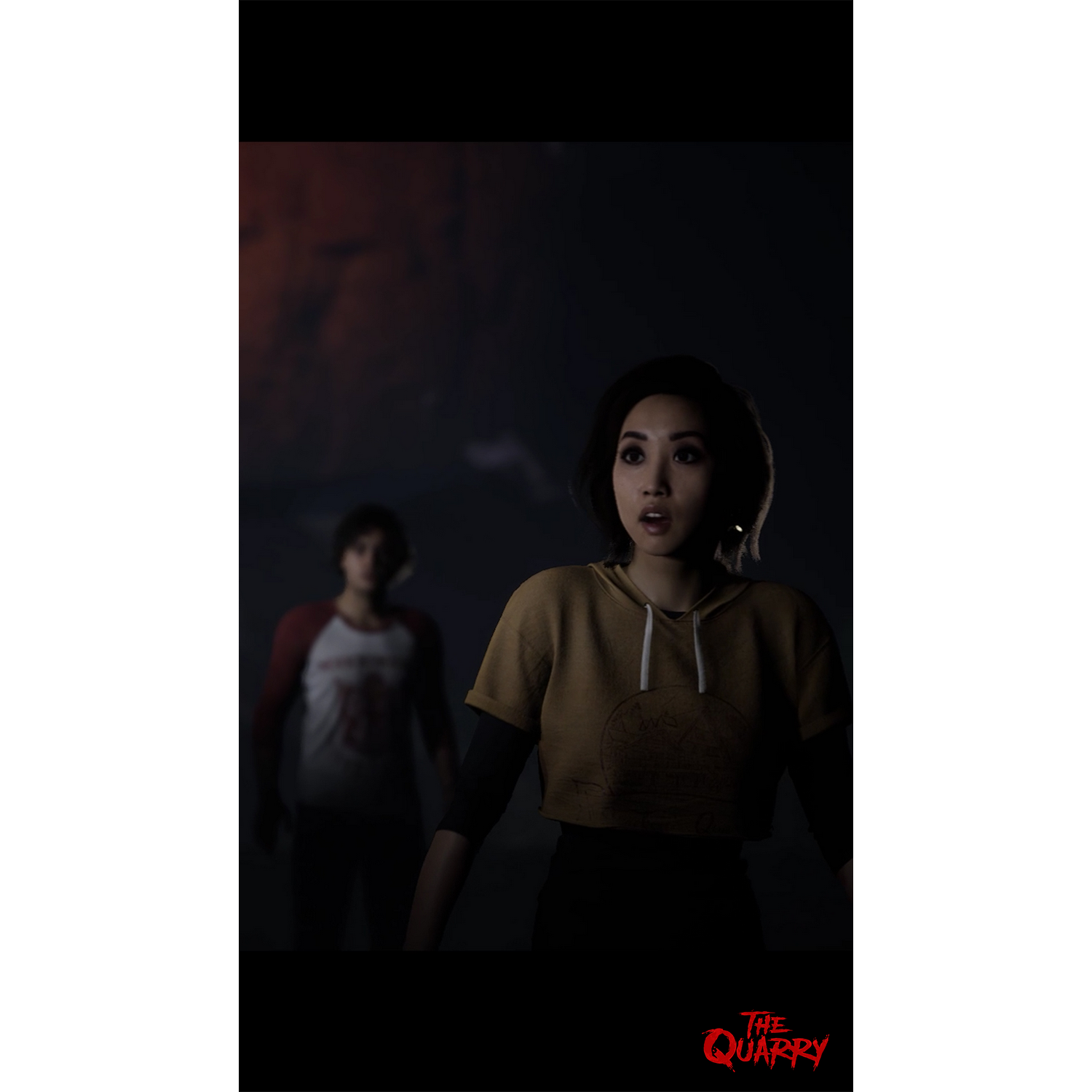 Dos personas en un entorno oscuro, una sorprendida, otra desenfocada.