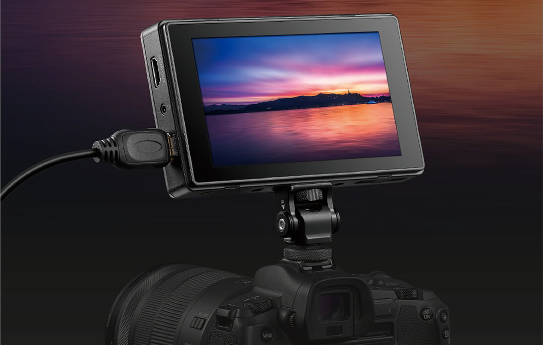 Ein kleiner Monitor zeigt einen Sonnenuntergang über dem Wasser, angeschlossen an eine Kamera.