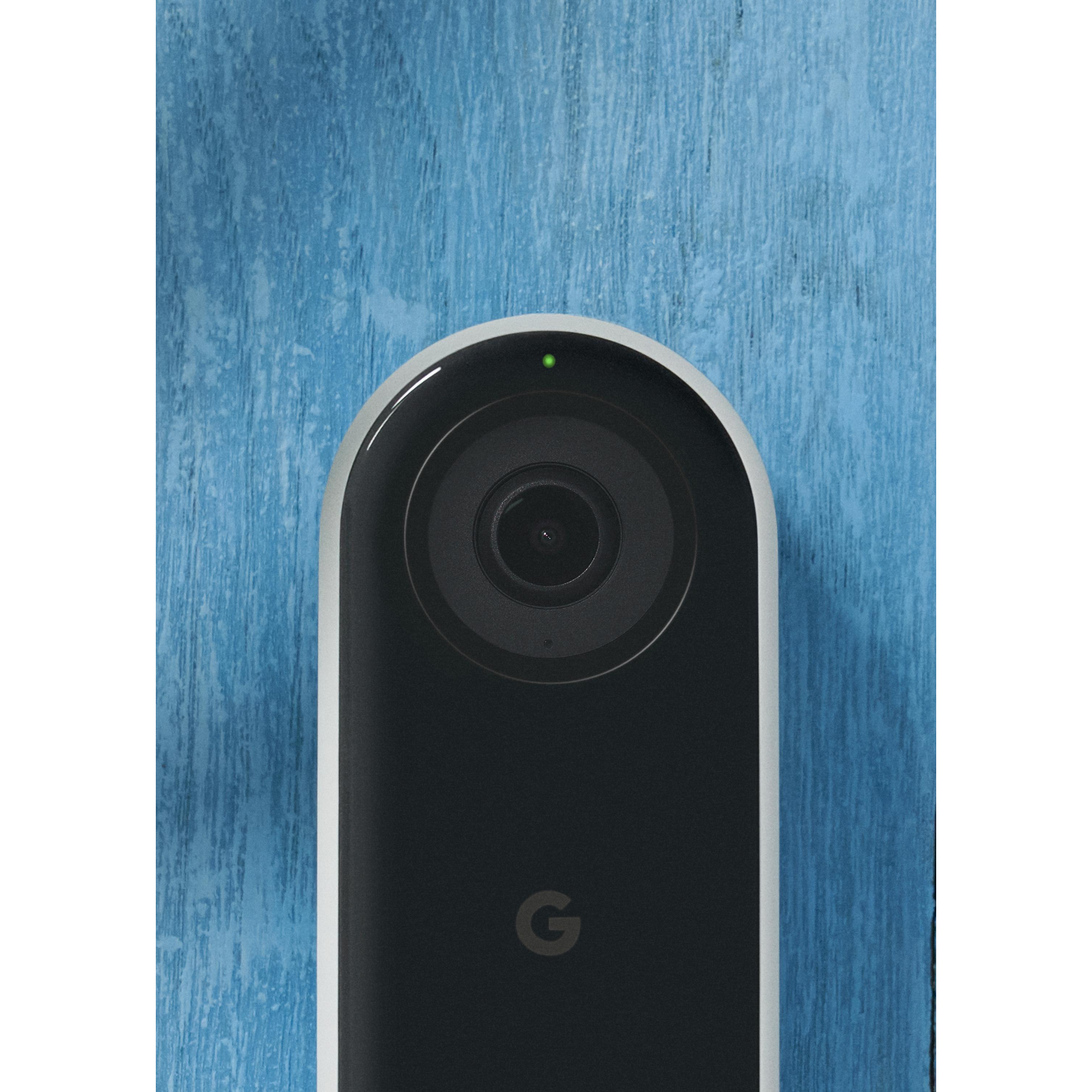 Un timbre Nest negro con cámara y luz verde, montado en un fondo de madera azul.