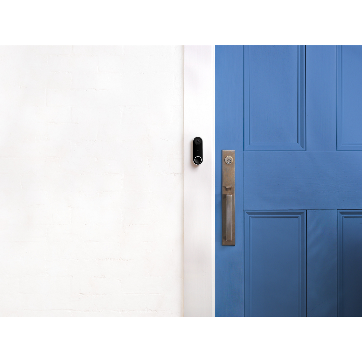 Una pared blanca con un timbre negro y una puerta azul con manija.
