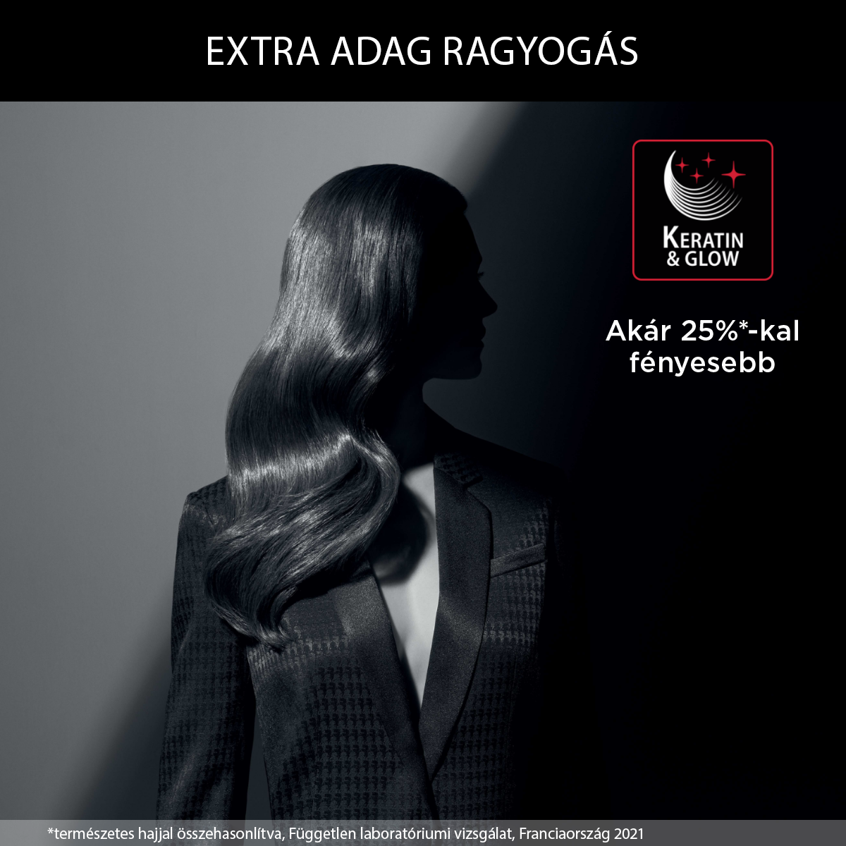 Nő öltönyben, háttal a kamerának. Szöveg: EXTRA ADAG RAGYOGÁS, Keratin & Glow.