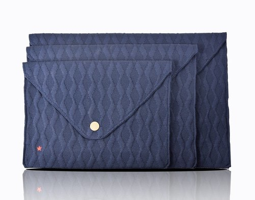 Trois enveloppes en tissu bleu marine avec un motif de losanges et une fermeture à bouton doré.