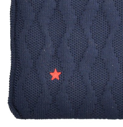 Couverture en tricot bleu avec une étoile rouge. La couverture a un motif de losanges.