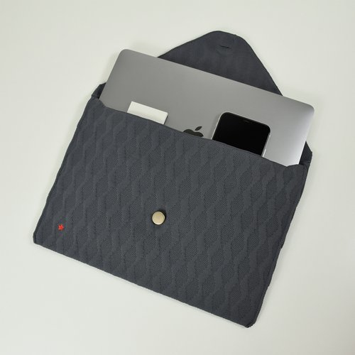 Grey laptop case with a laptop and a phone inside. A red star is on it.