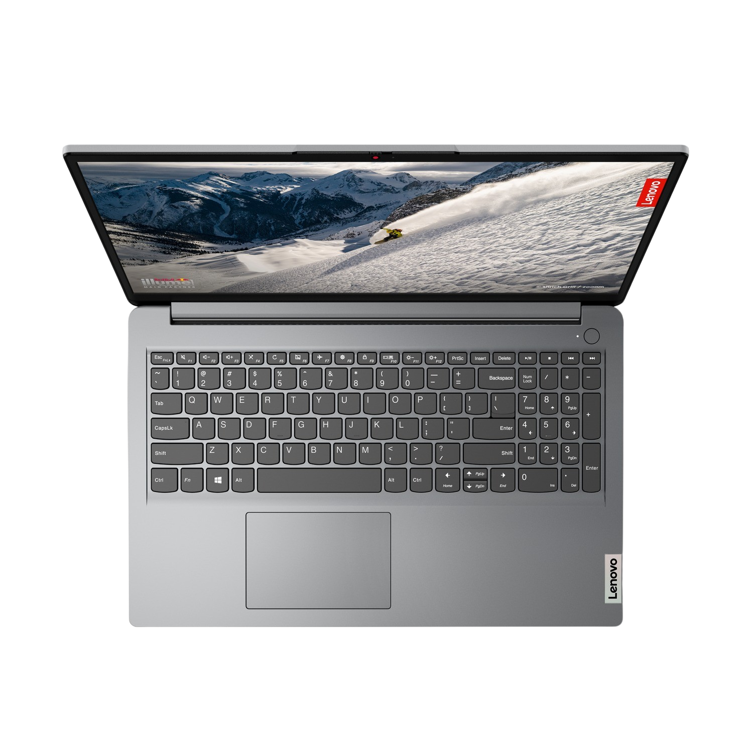 Ordenador portátil abierto. La pantalla muestra montañas nevadas. Teclado y panel táctil visibles. Logo Lenovo.