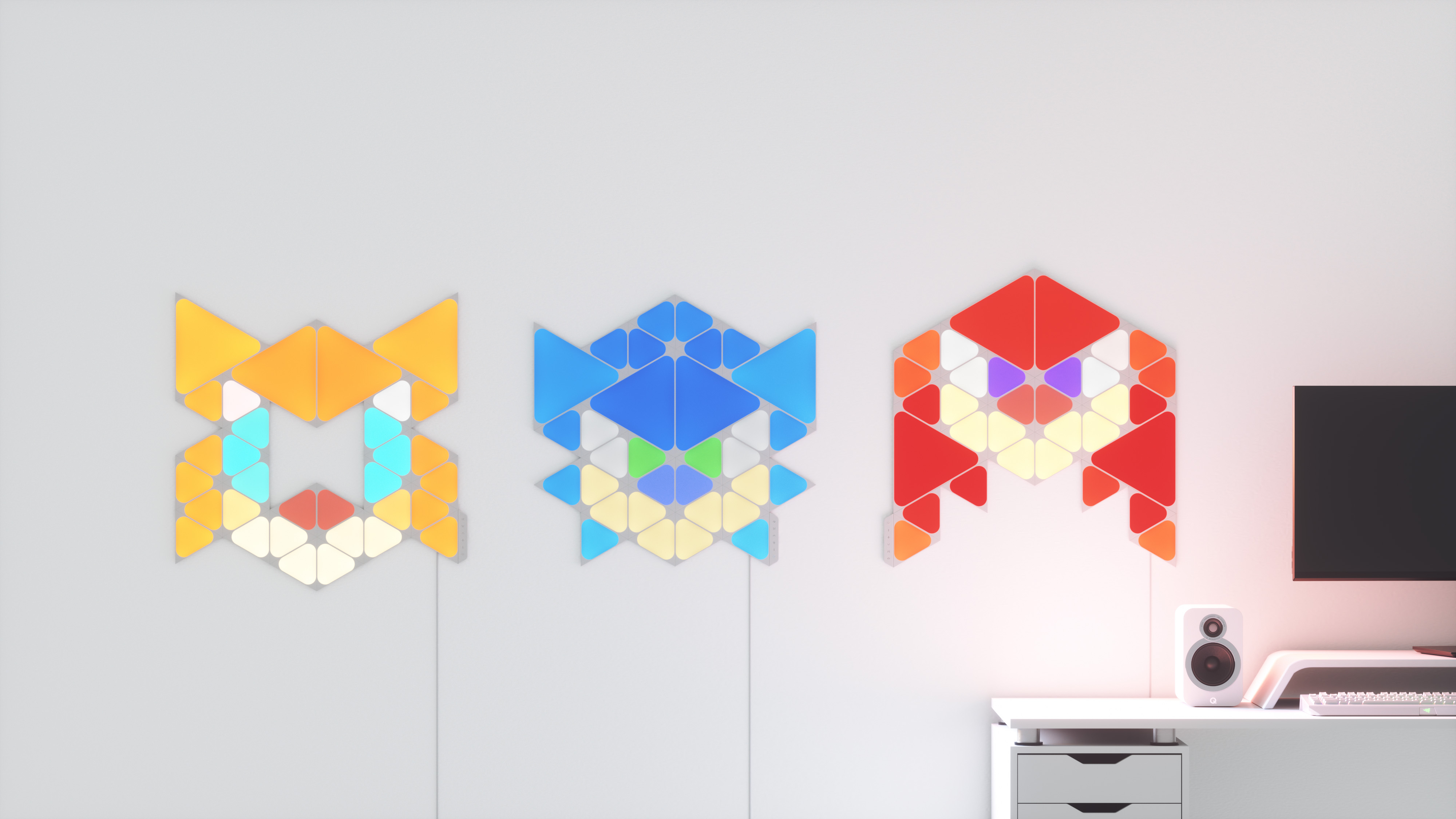 Drei farbenfrohe geometrische Lichter an einer Wand. Sie haben verschiedene Formen und Farben.