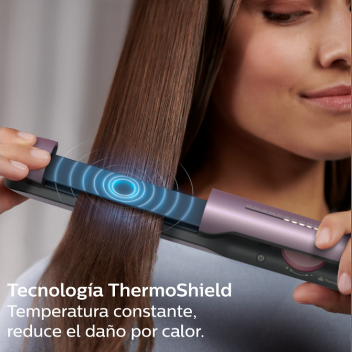 Mujer usando una plancha de pelo. La plancha está en acción, rodeada de texto.