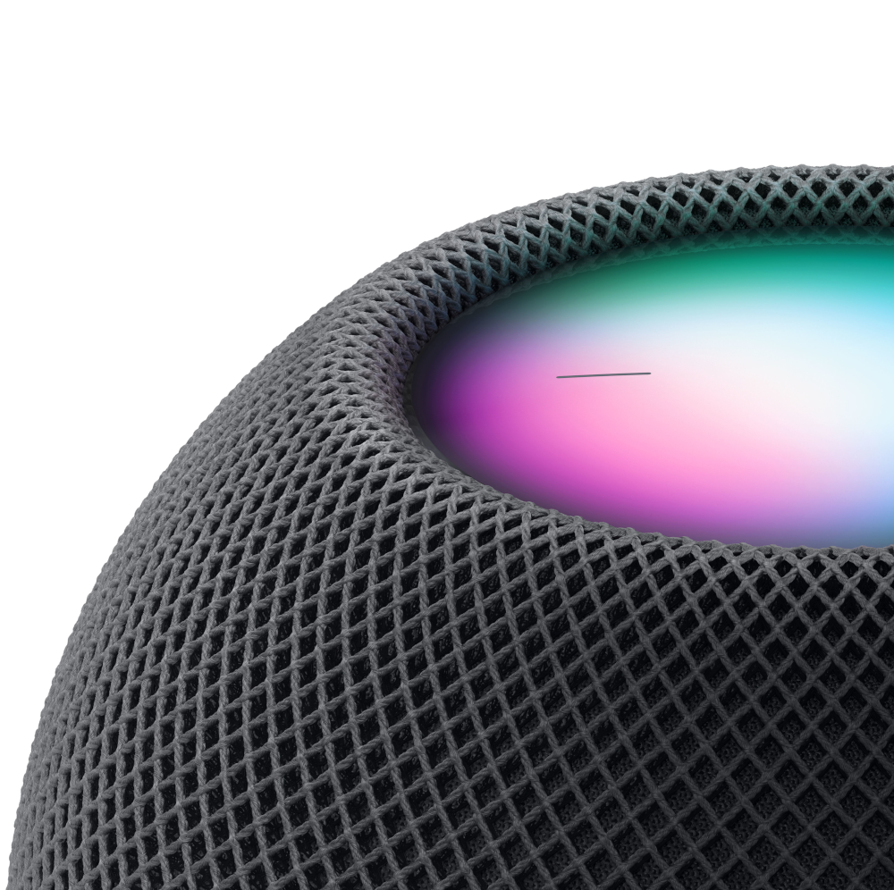 Gros plan sur un haut-parleur sphérique gris avec un design en maille et une lumière colorée.