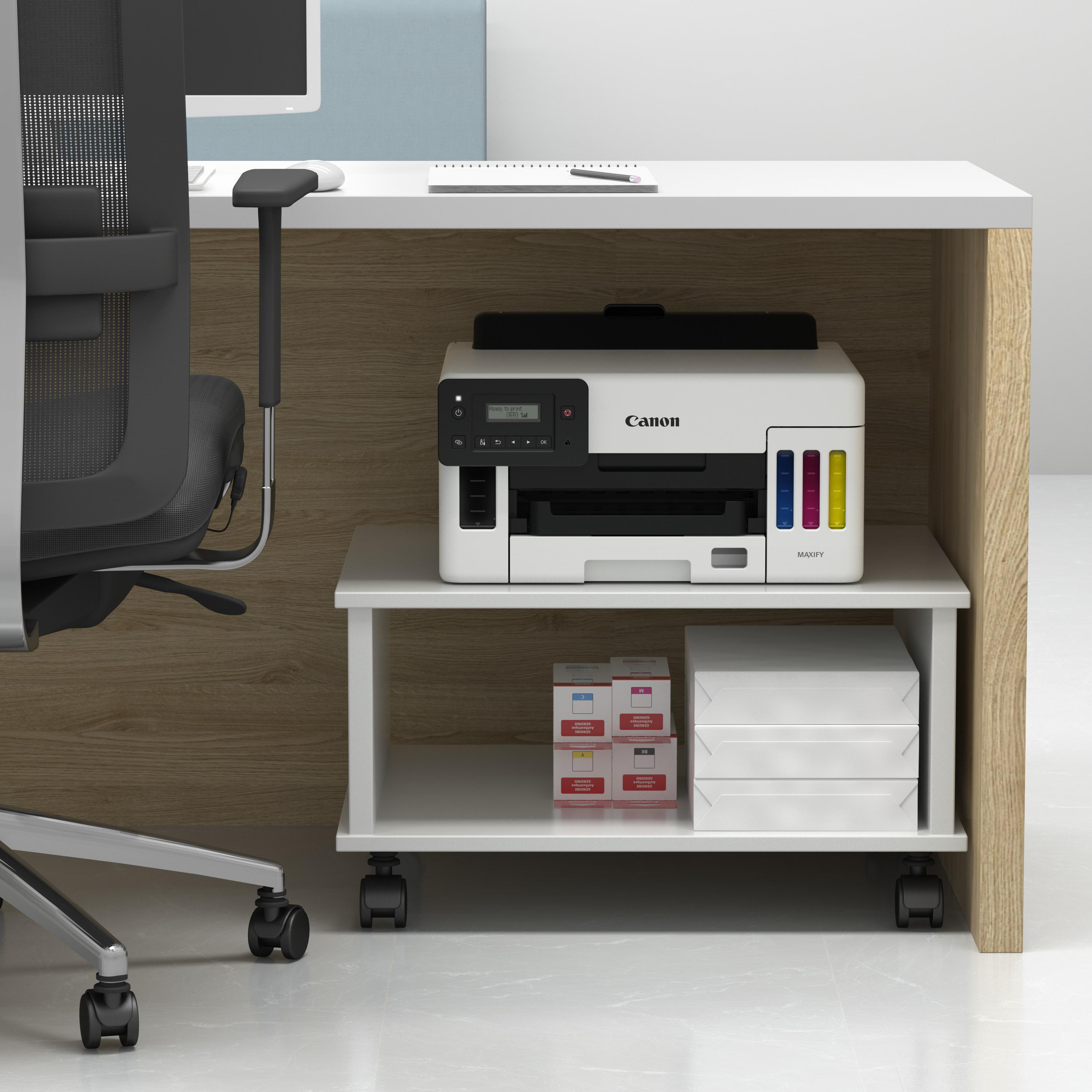 Ein Drucker steht auf einem Schreibtisch mit einem Druckerregal, auf dem Tintenpatronen und Papier liegen. Der Schreibtisch ist in einem Büro.