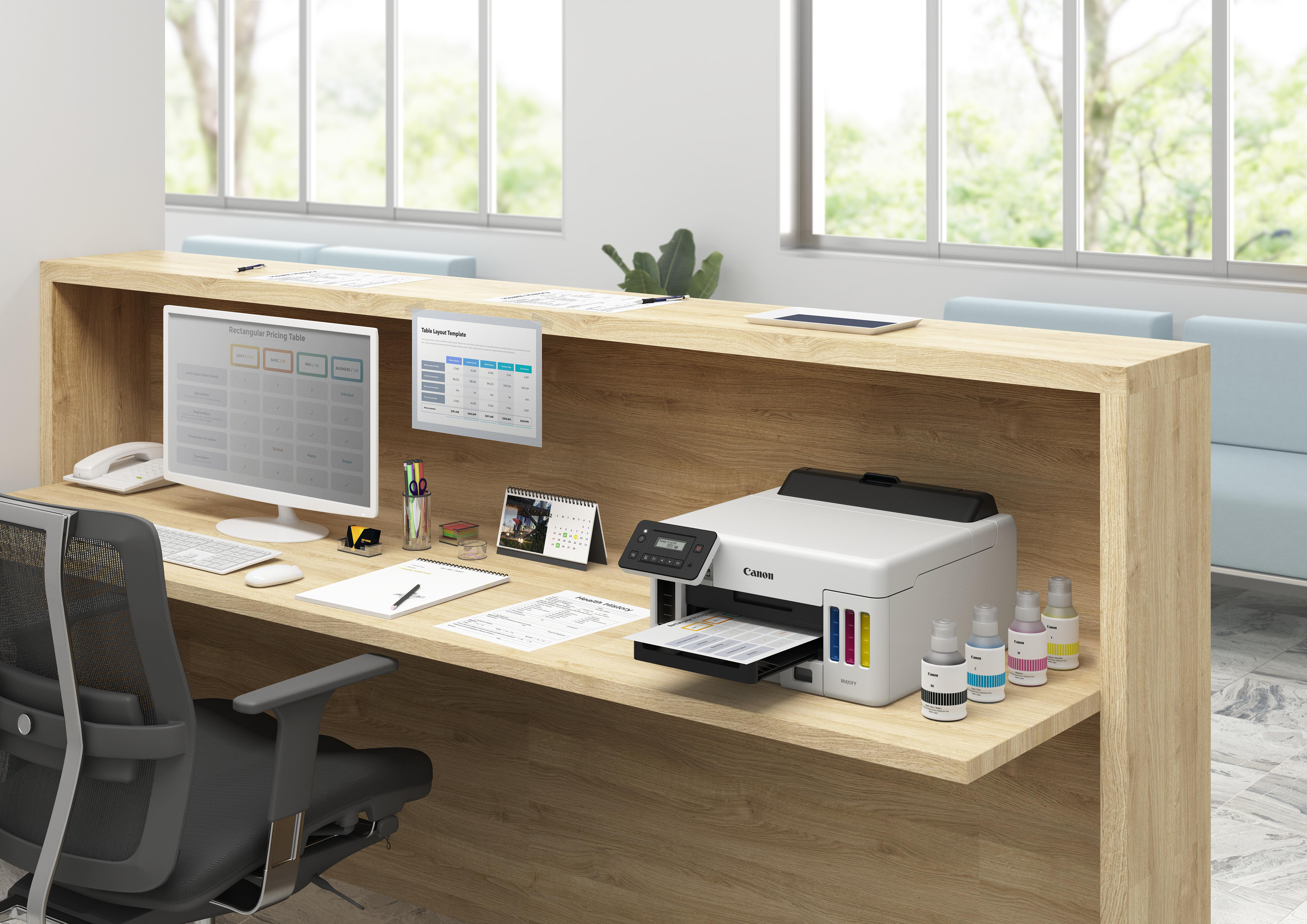 Bürotisch mit Drucker, Monitor und Zubehör. Ein Fenster und ein hellblaues Sofa sind im Hintergrund.