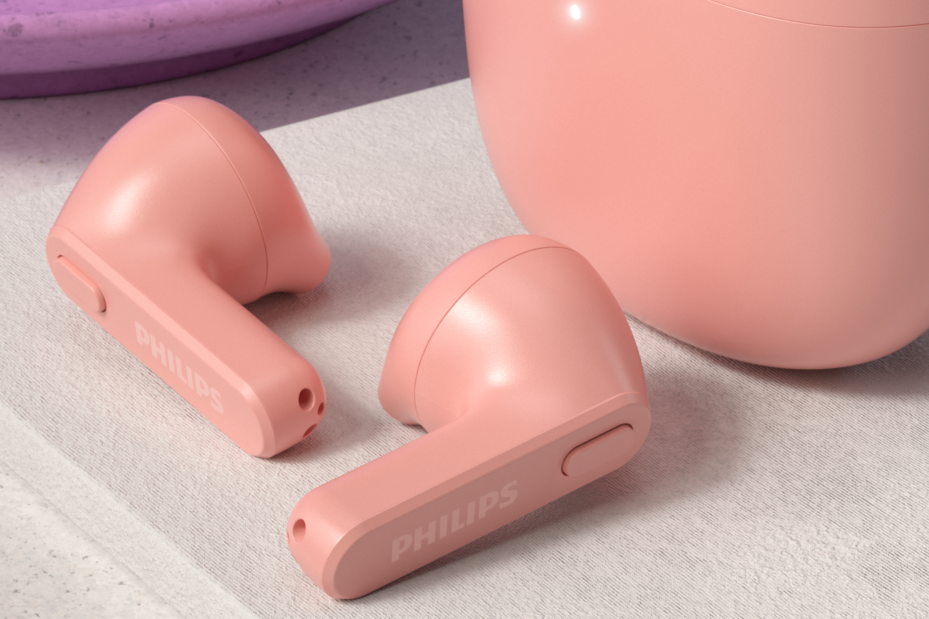 Nötr bir yüzey üzerinde iki pembe kablosuz kulaklık, Philips logosu görünür.