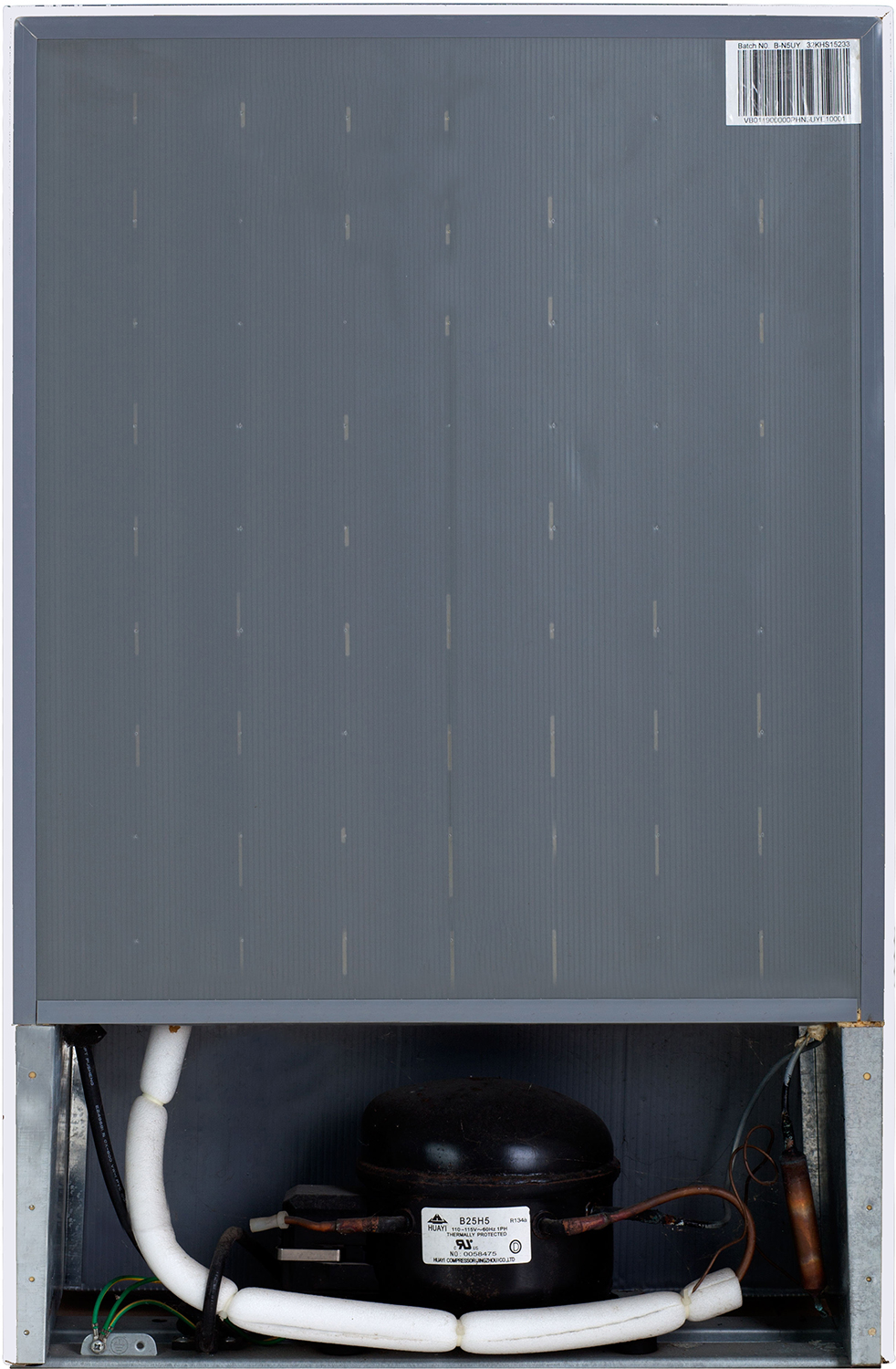 Back of a refrigerator. Grey back panel, black compressor at the bottom, white pipes.