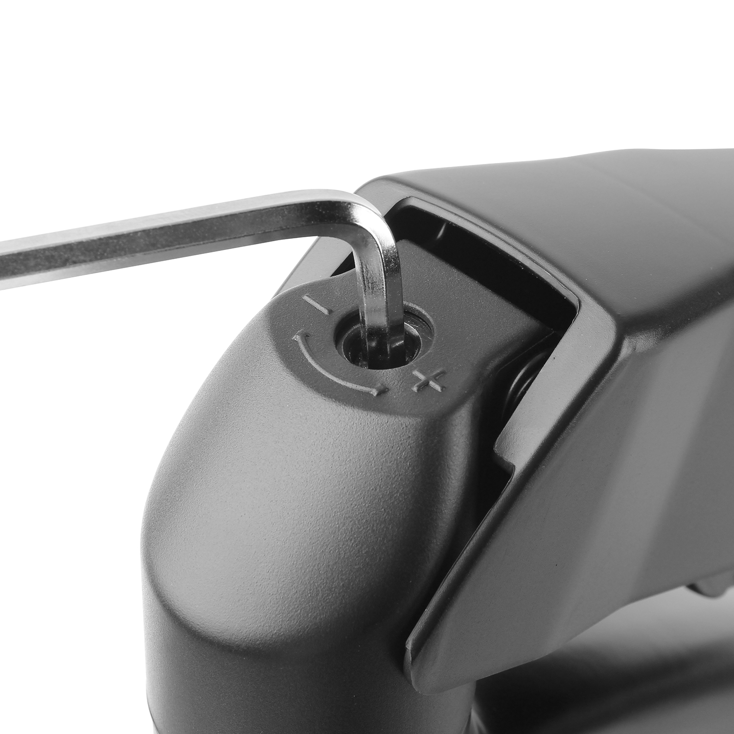 A hex key inserted into a screw on a black object. The hex key is silver.