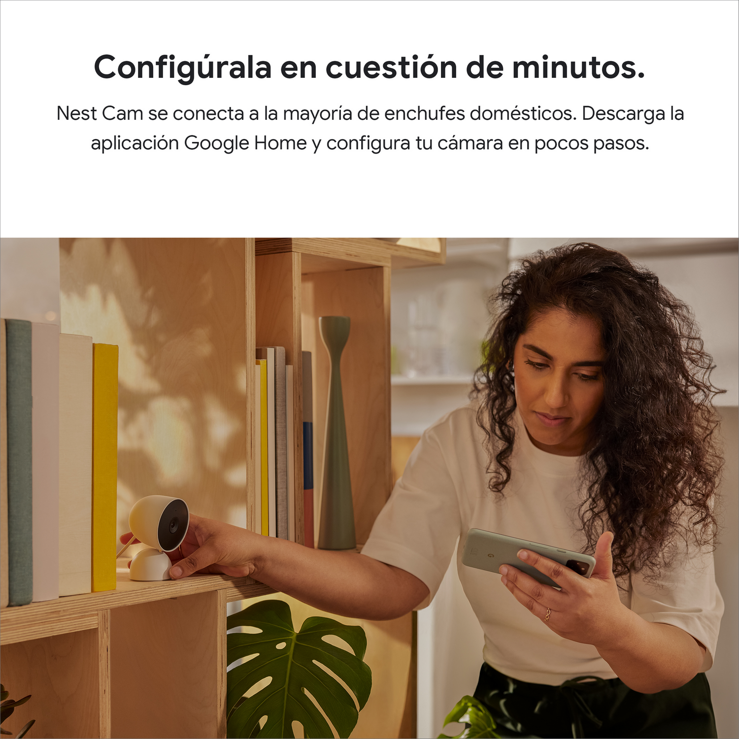 Mujer usando teléfono junto a estante con cámara en estante.