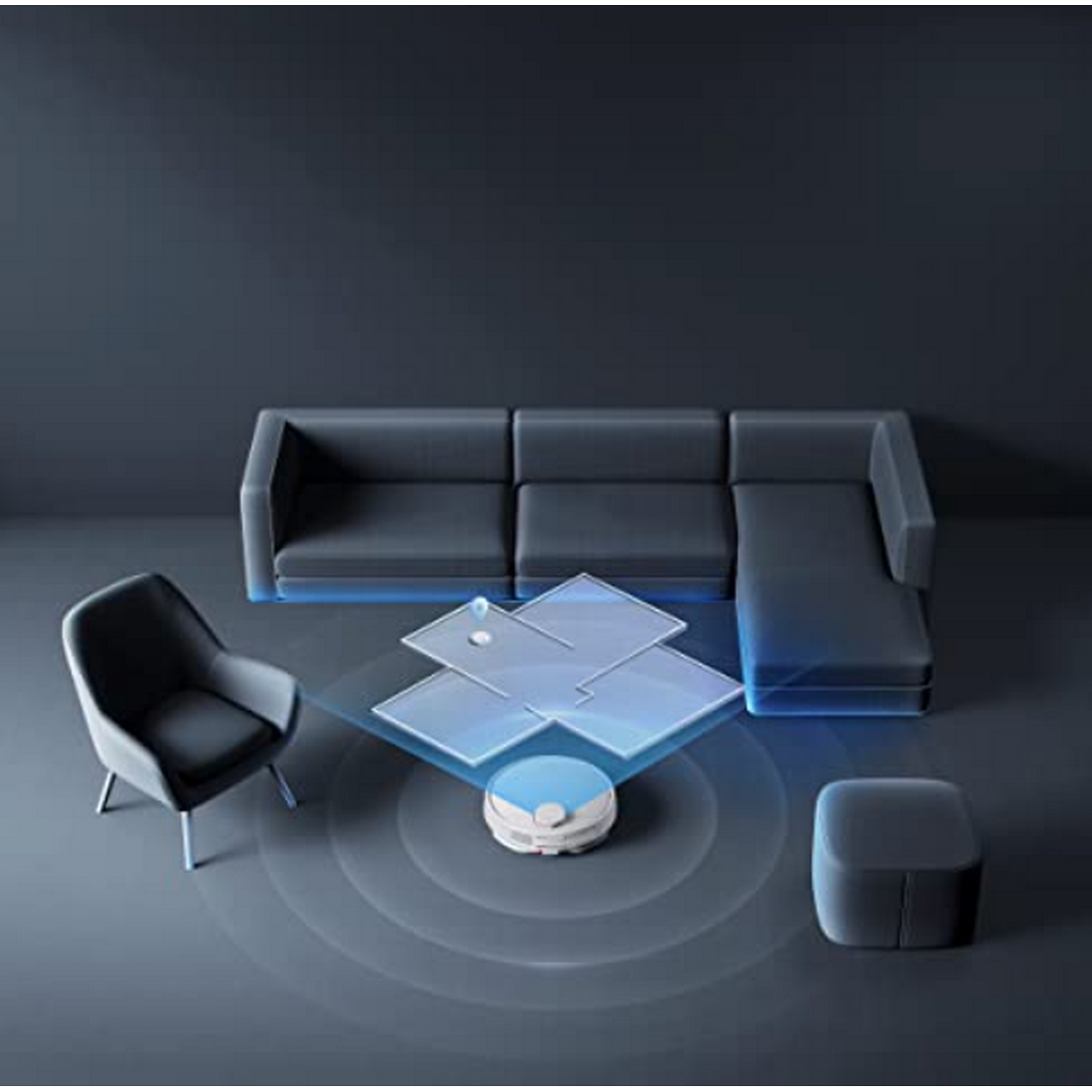 Una aspiradora automática en un piso oscuro. Una silla gris, un sofá y una mesa pequeña también están en la habitación.