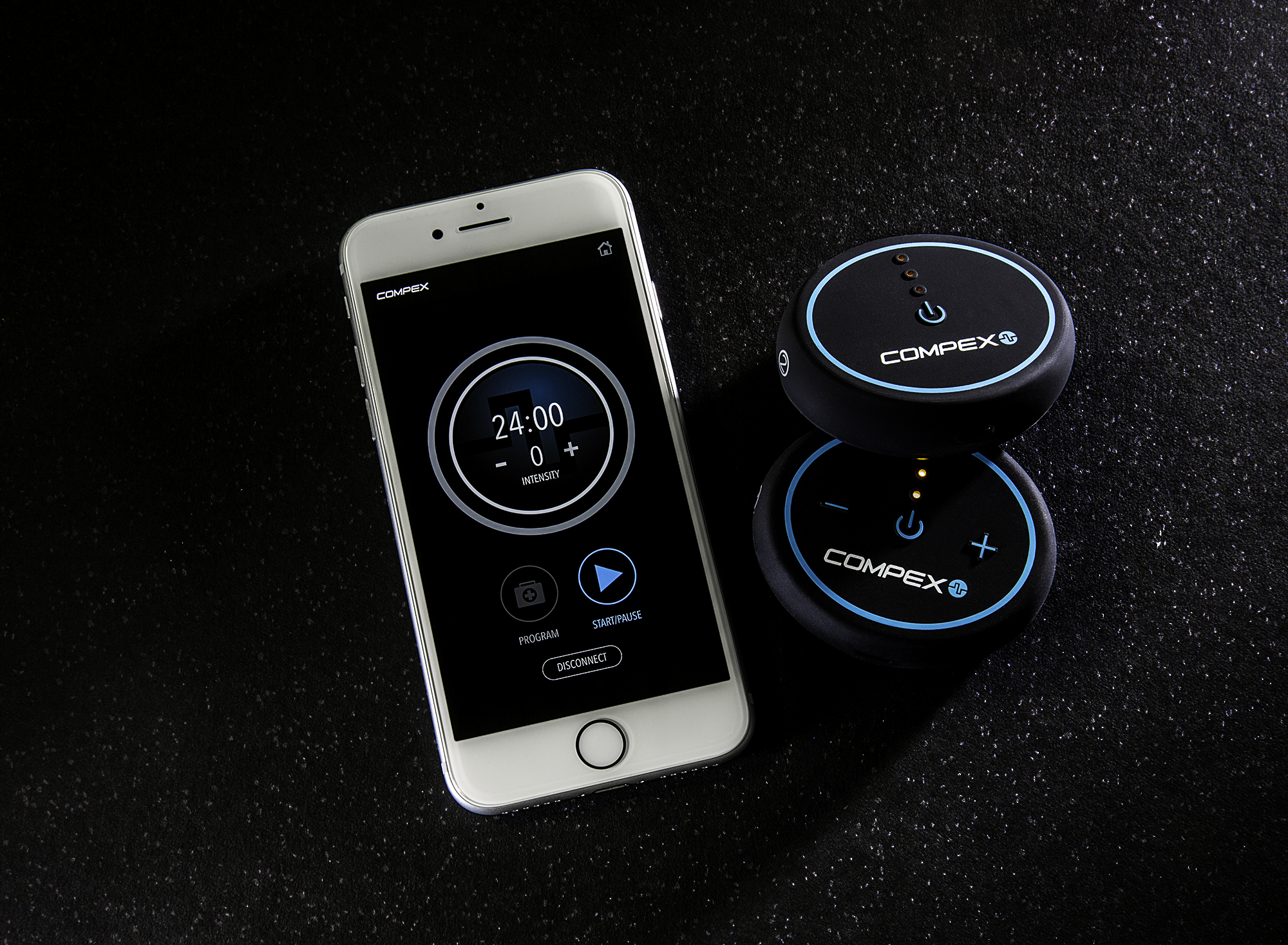 Smartphone mit Fitness-App-Oberfläche und zwei schwarzen Compex-Muskelstimulatoren.