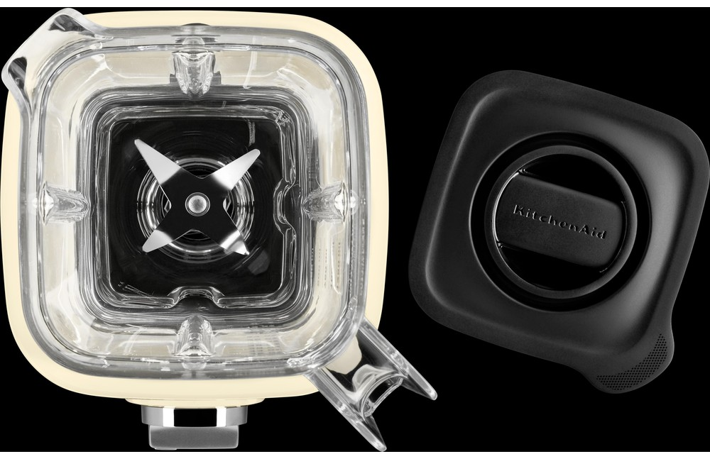 Crèmekleurige blender met een transparante kan, een zwart deksel en een roestvrijstalen mes. KitchenAid logo op het deksel.