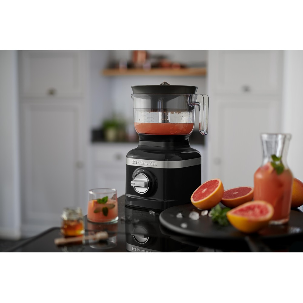 Black KitchenAid food processor with pink drink and grapefruit.