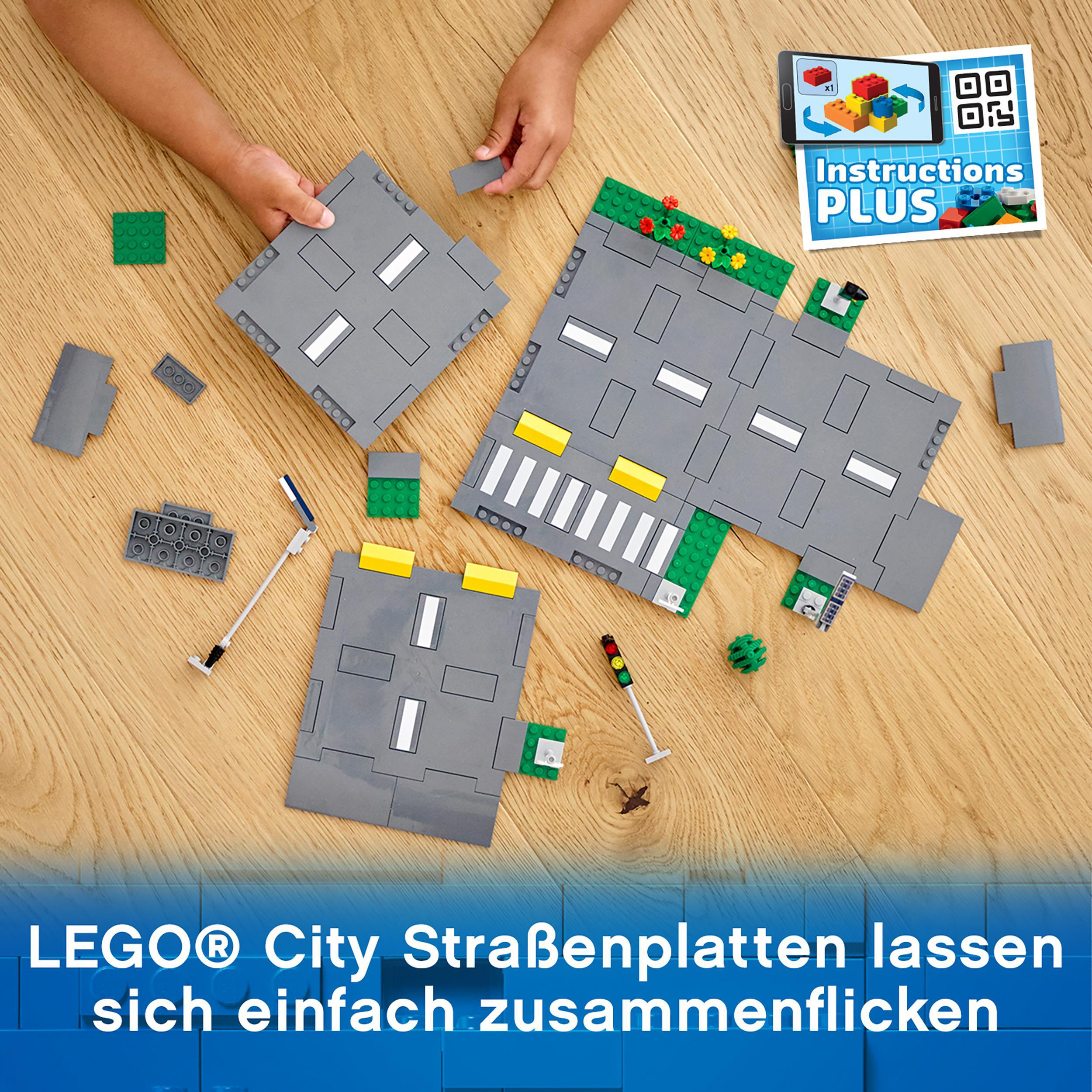 Lego-Straßenplatten werden auf einer Holzoberfläche platziert. Anweisungen sind in der Ecke.