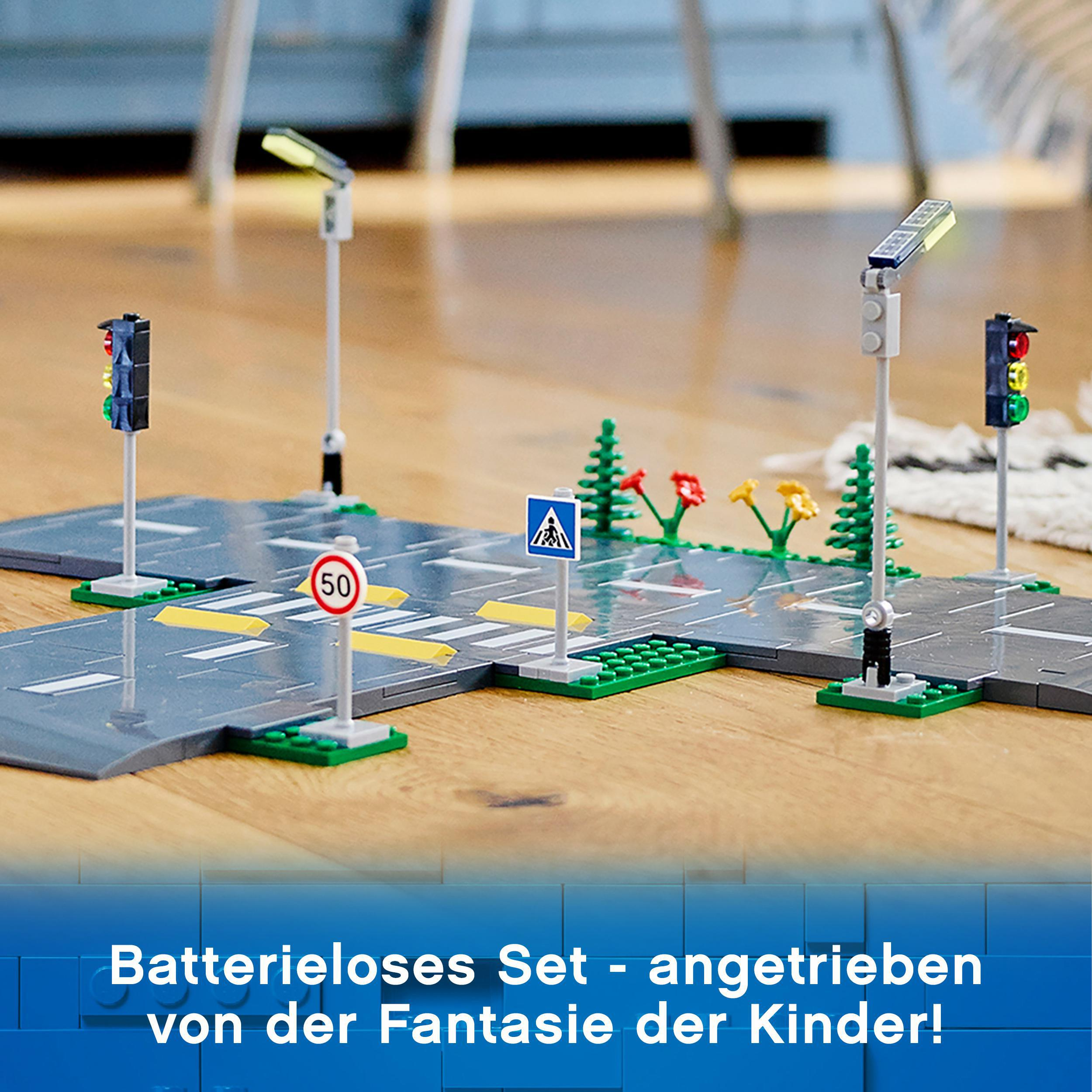 Spielzeug-Straßenaufbau mit Straßenschildern, Ampeln und einer Lego-Straße.