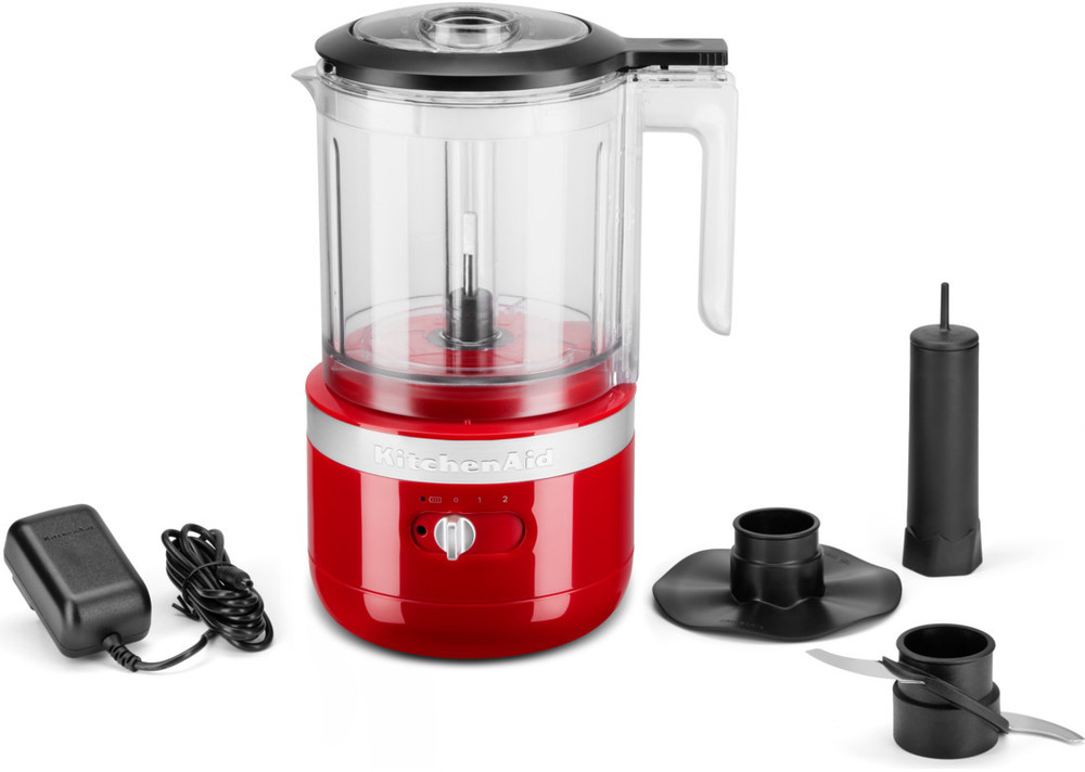 Rode KitchenAid keukenmachine met accessoires op een wit oppervlak.