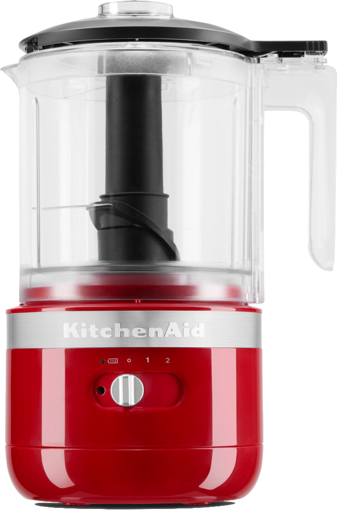 Een rode KitchenAid foodprocessor. Hij heeft een doorzichtige plastic kom en een zwart mes. Er zit een draaiknop aan de voorkant.