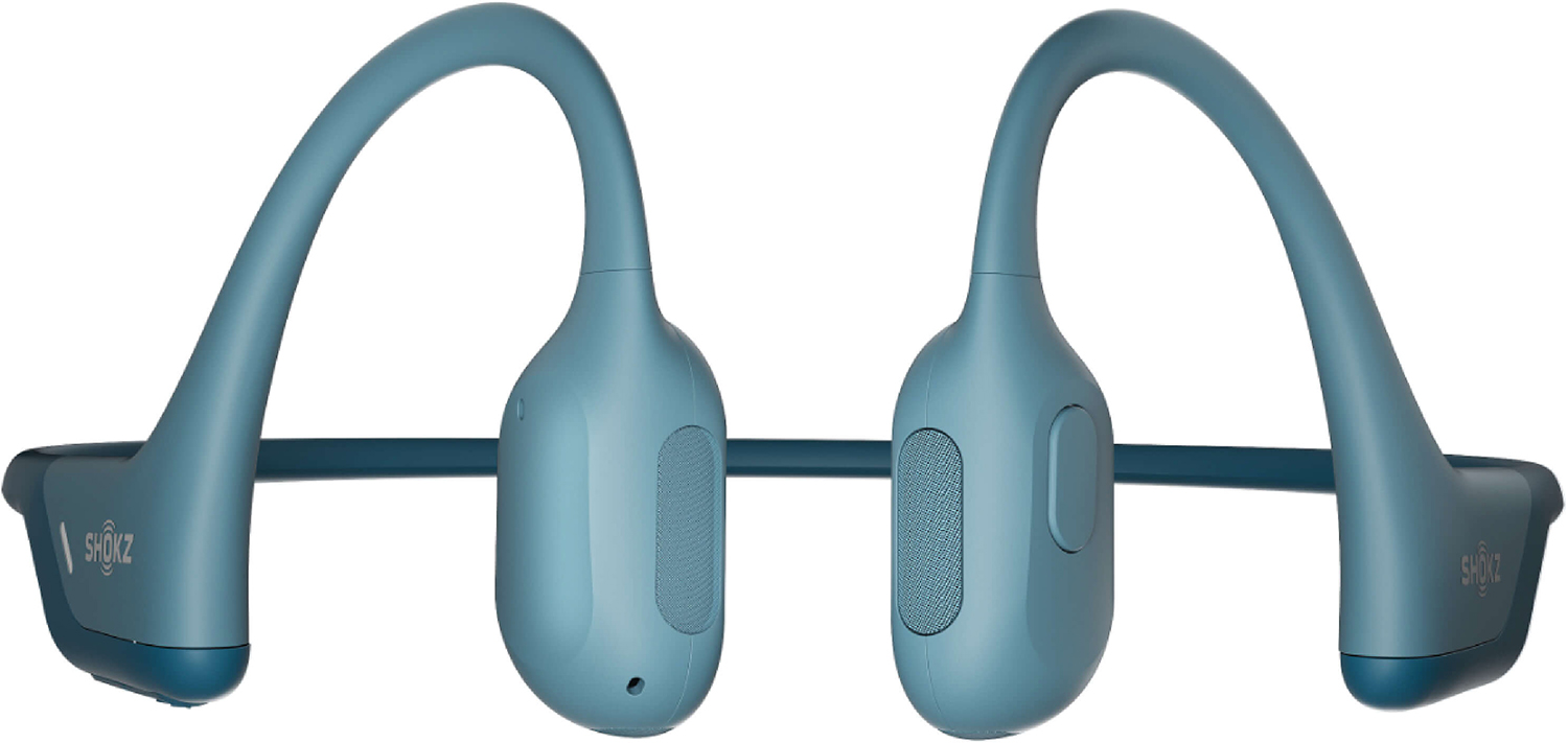 Blue Shokz bone conduction headphones, resting on a white surface.