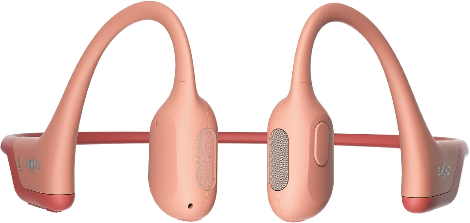 Roze bone conduction koptelefoon. Gebogen ontwerp met oorhaken en centrale modules. Rode accenten op de uiteinden en band.