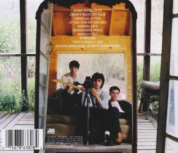 CD-Albumcover. Eine Band sitzt auf einer Treppe, mit Gitarre und Kamera.