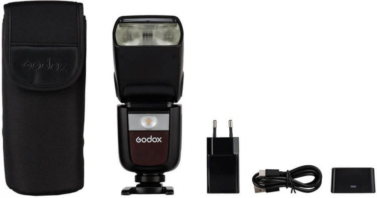 Un flash d'appareil photo Godox noir avec des accessoires dans un studio.