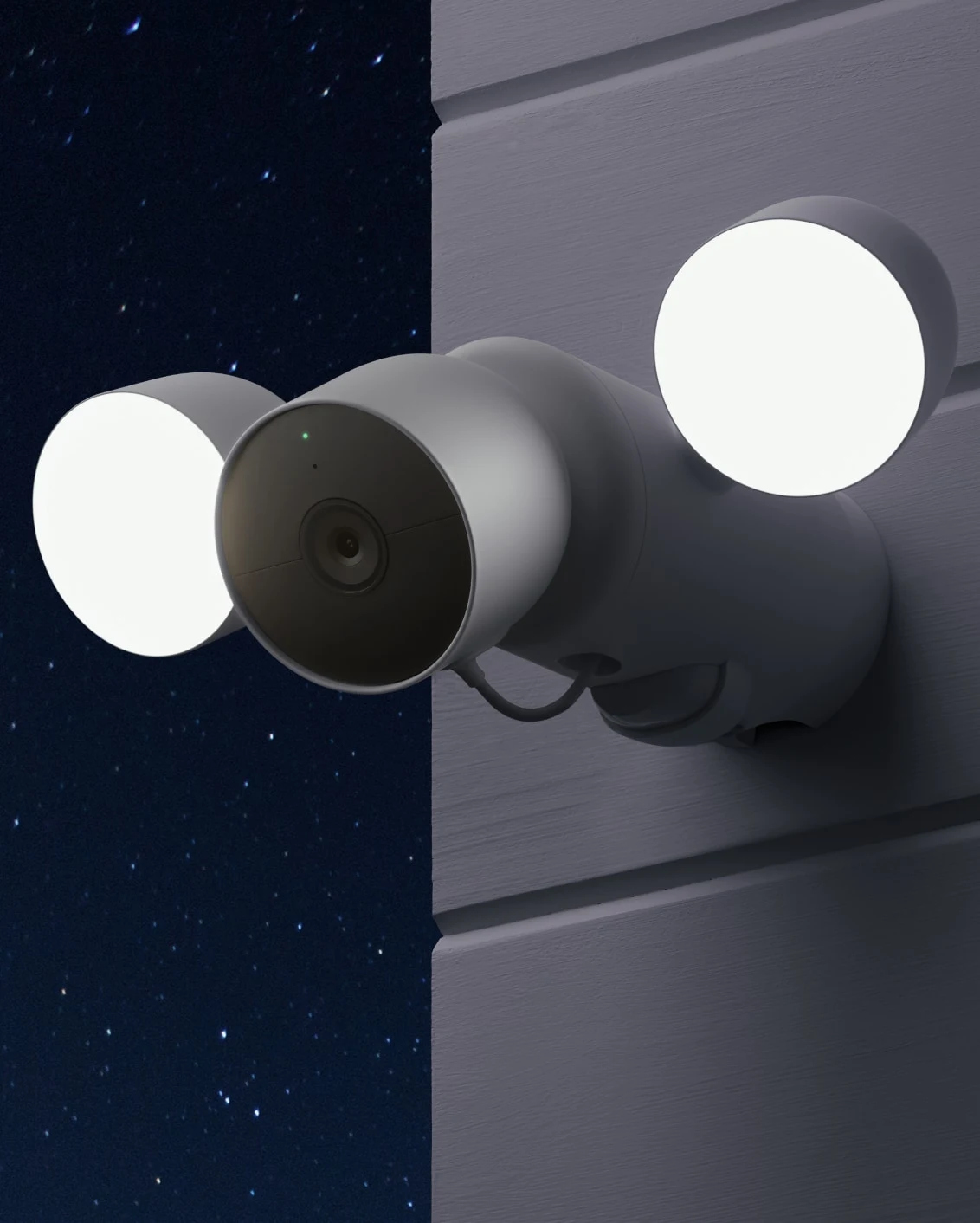 A security camera with two lights mounted on a white wall, with a night sky background.