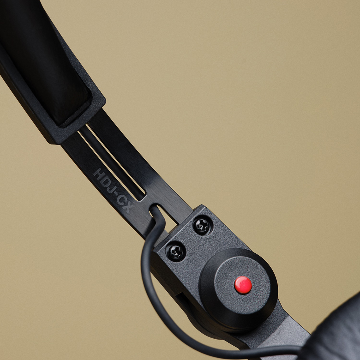 Primo piano delle cuffie, fascia nera con testo HDJ-CX e un pulsante rosso.