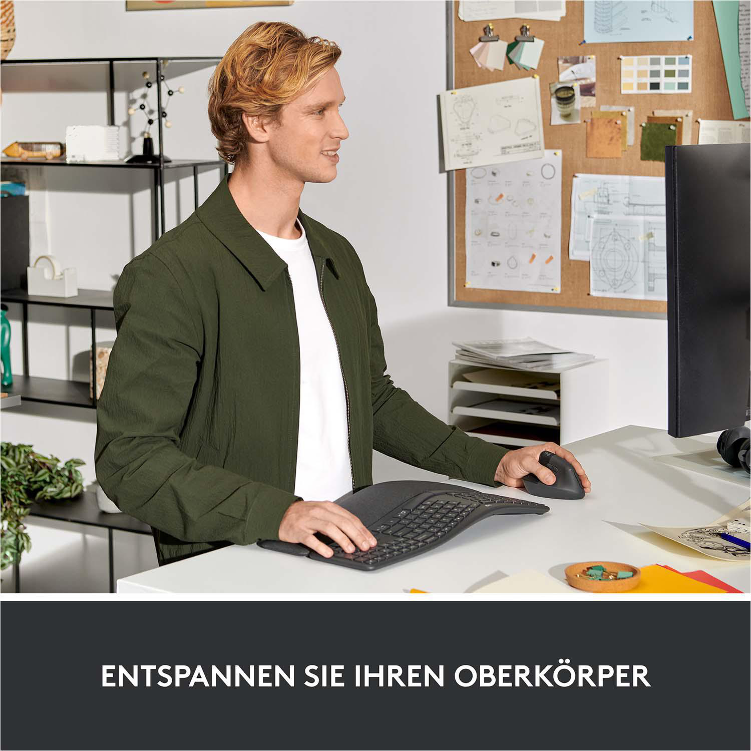 Mann benutzt geschwungene Tastatur und Maus am Schreibtisch.