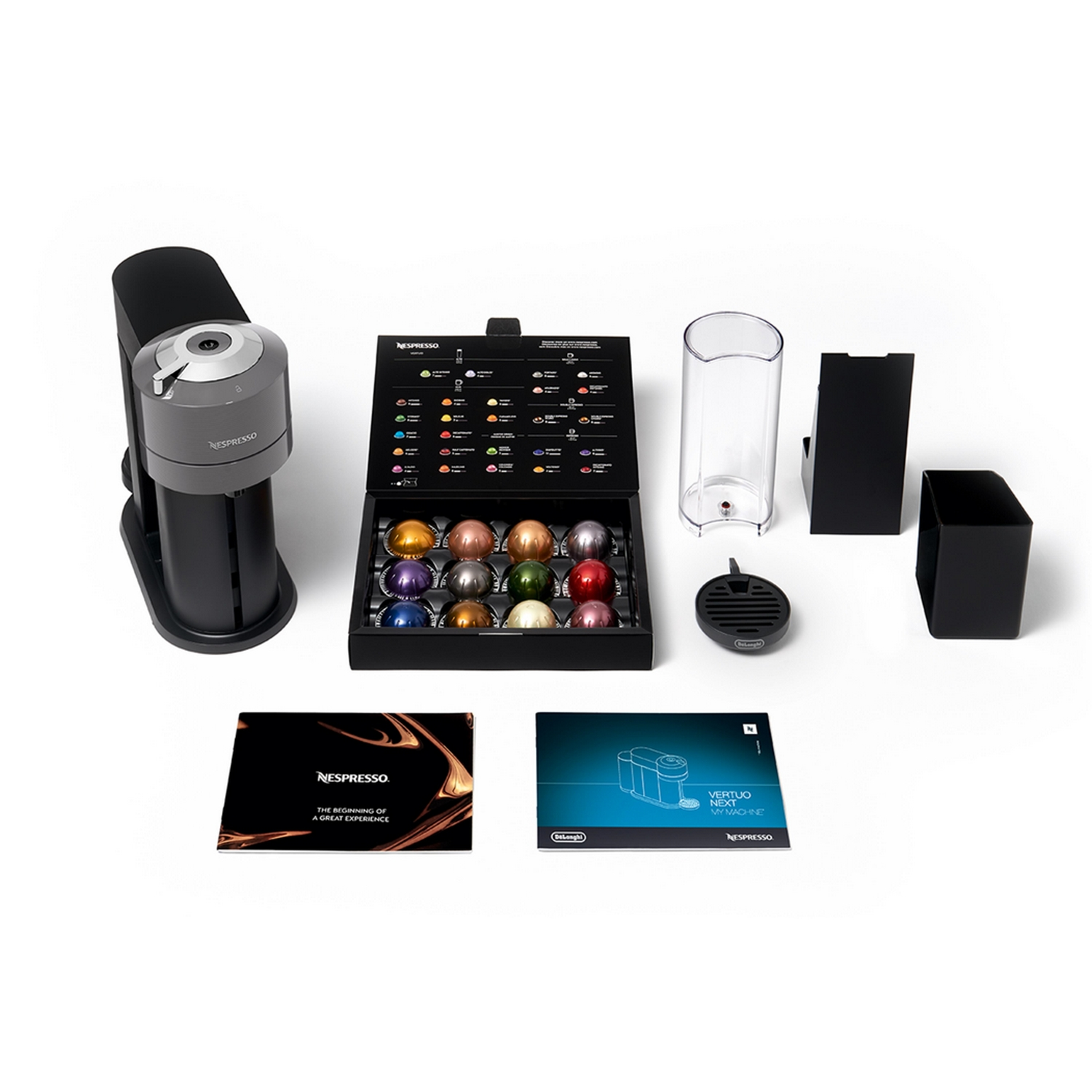 Una cafetera Nespresso con cápsulas, accesorios y una caja de cápsulas.