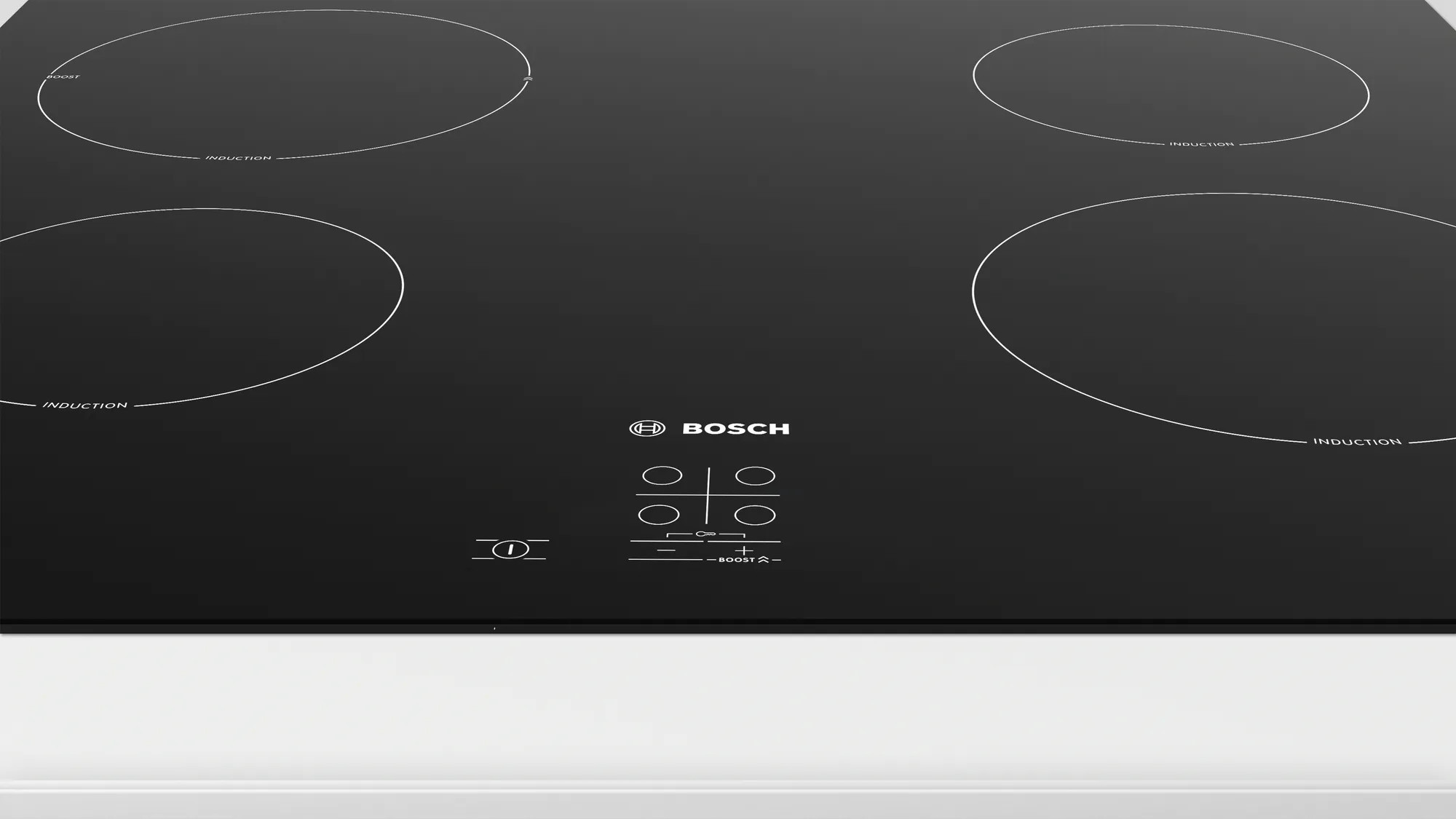 Table de cuisson à induction noire avec quatre zones de cuisson circulaires et panneau de commande.