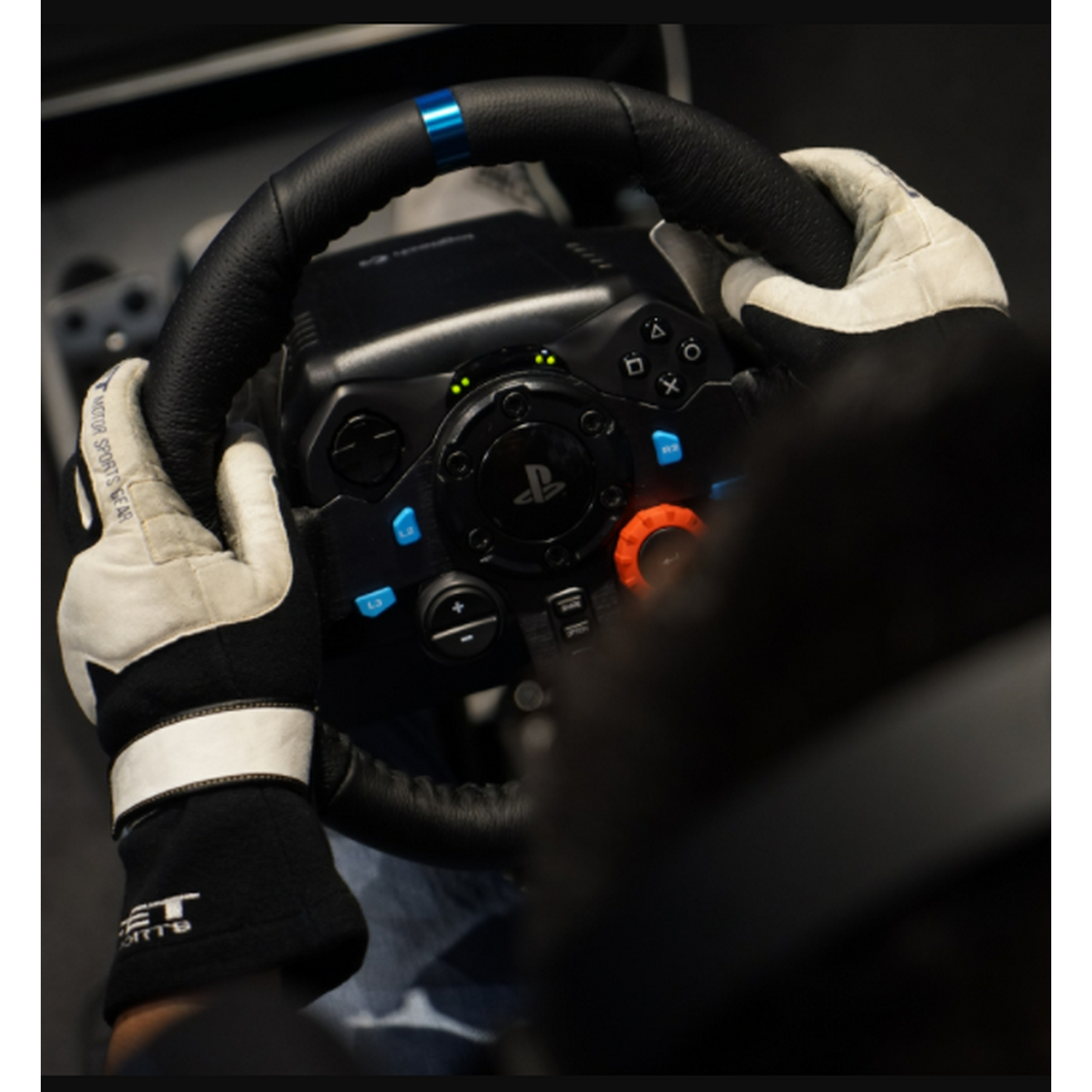 Una persona con guantes sostiene un volante, parte de una configuración de juego.