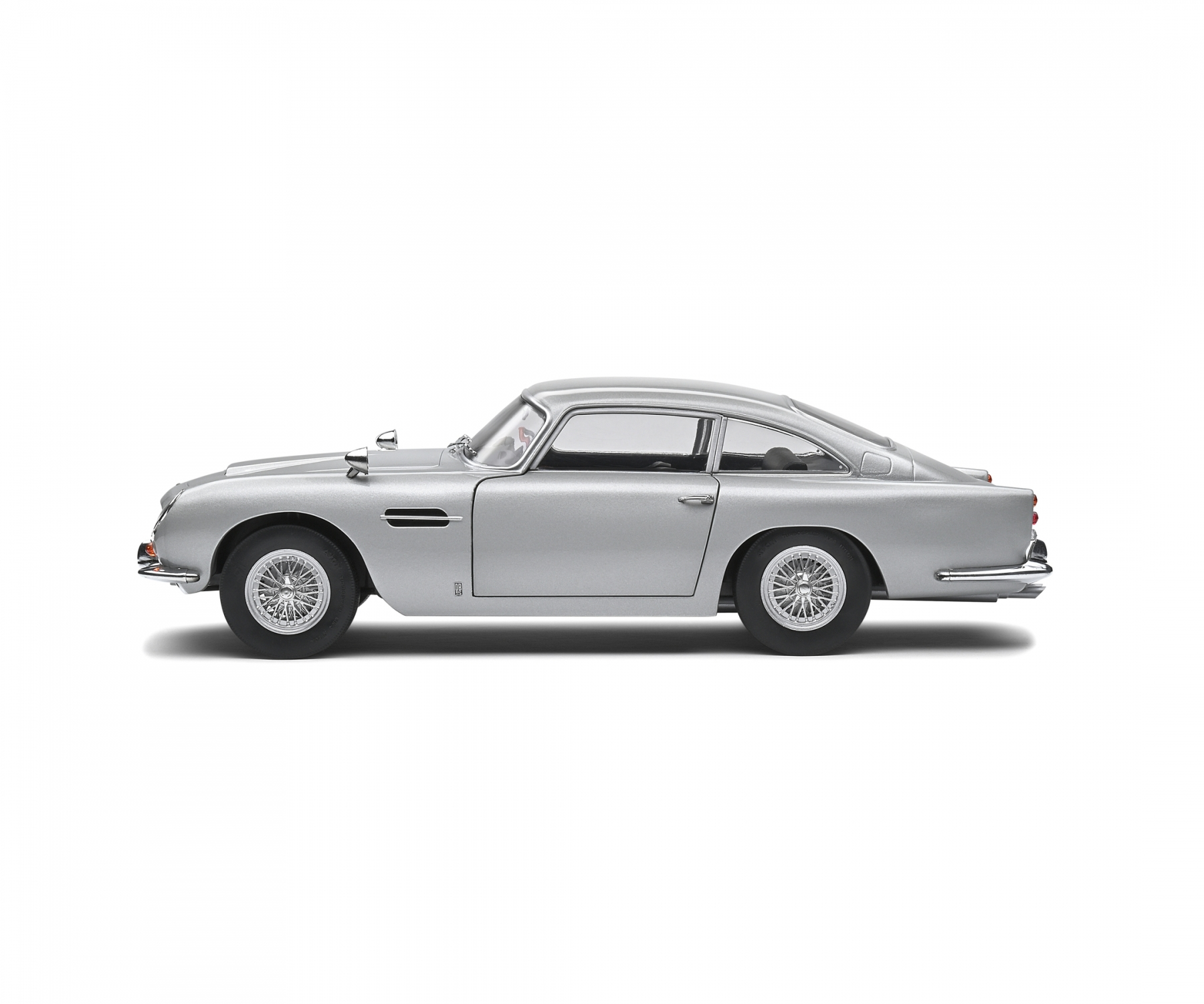 Ein silbernes Oldtimer-Auto im Profil. Es hat ein schlankes Design, Speichenräder und befindet sich vor weißem Hintergrund.