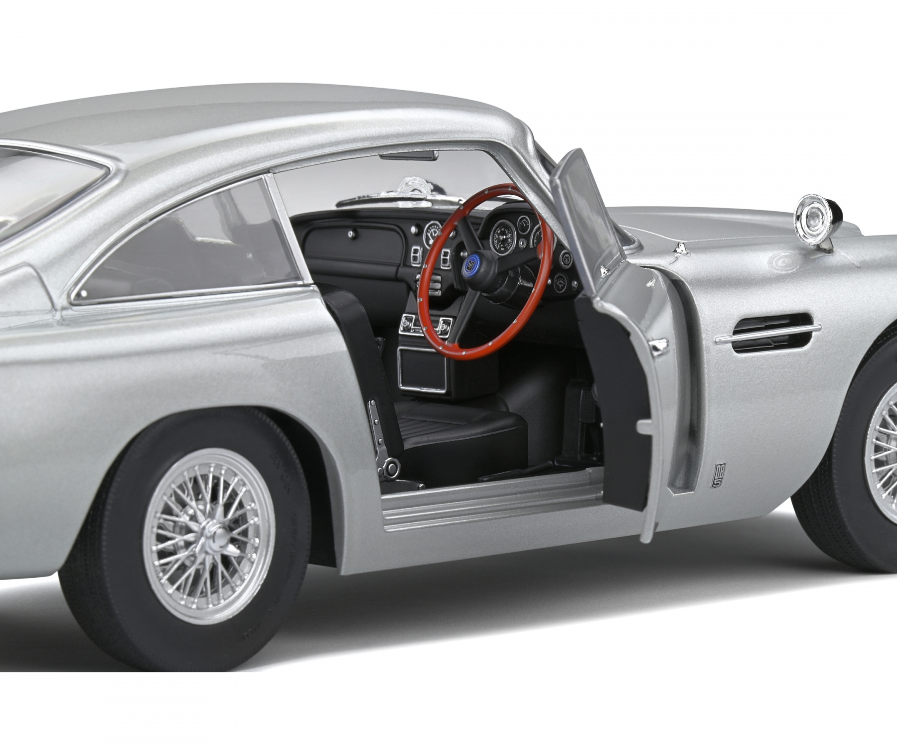 Silbernes Oldtimer-Modell mit offener Tür, rotem Lenkrad, detailliertem Innenraum und Drahträdern, vor weißem Hintergrund.