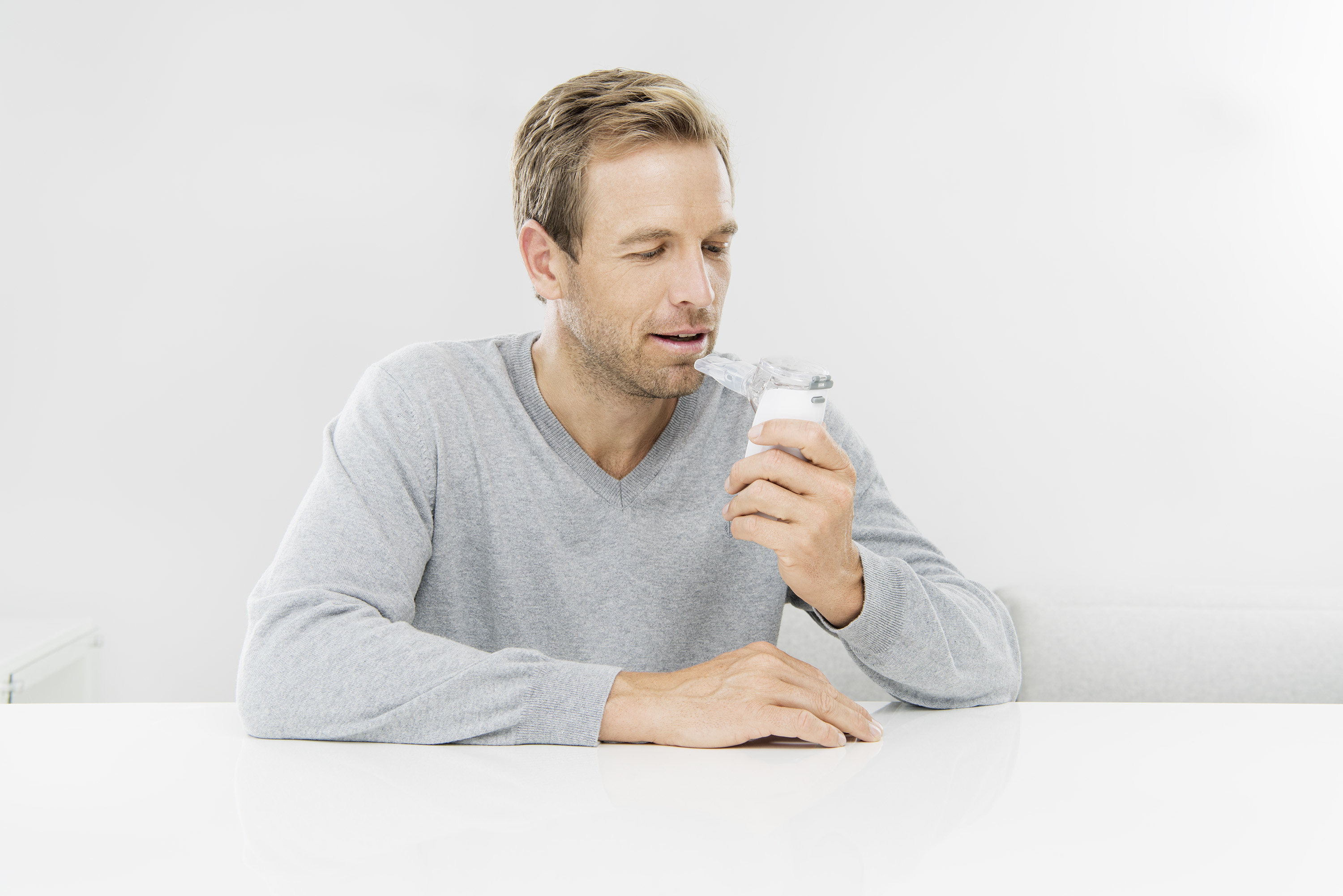 Ein Mann, der einen Vernebler hält und betrachtet.