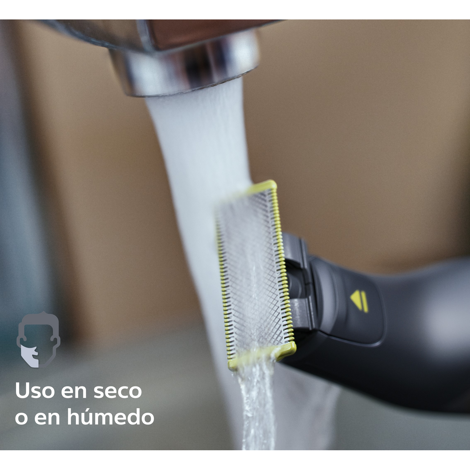 Primer plano de afeitadora eléctrica bajo agua corriente. El texto es en español.