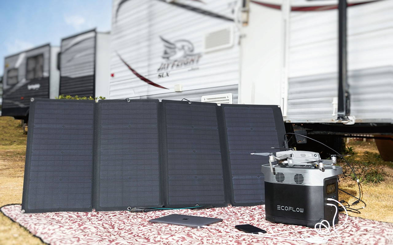 Solarpaneele mit einer Drohne, einer Stromstation, einem Laptop und einem Telefon in der Nähe eines Anhängers.
