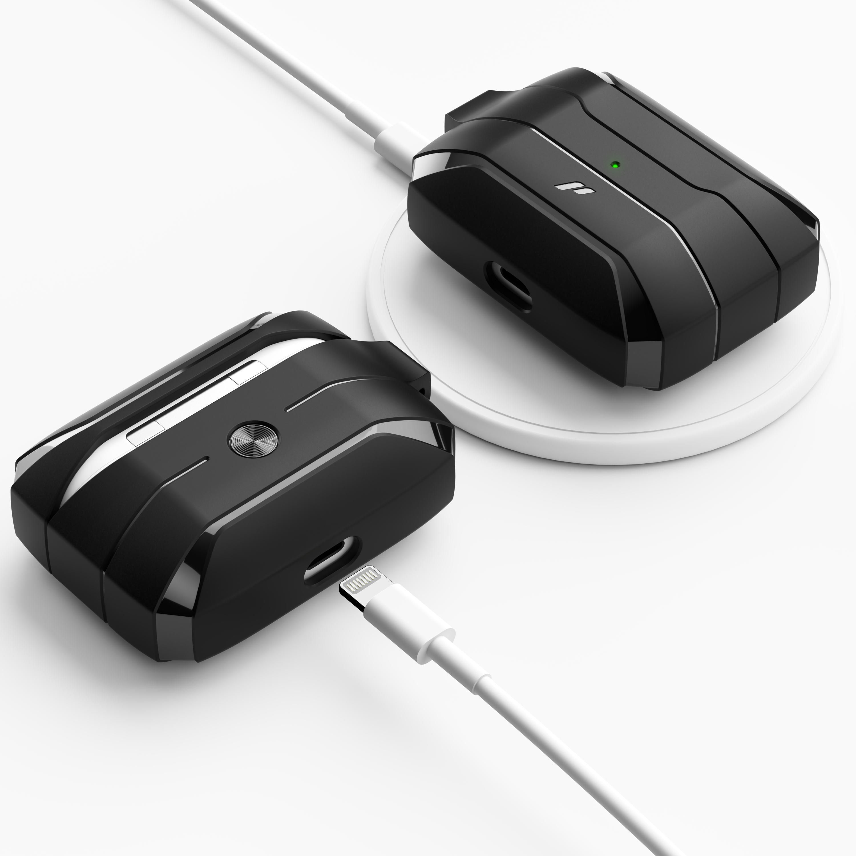 Zwei schwarze und silberne kabellose Ladekoffer, einer auf einem weißen Pad und einer mit einem weißen Kabel verbunden.