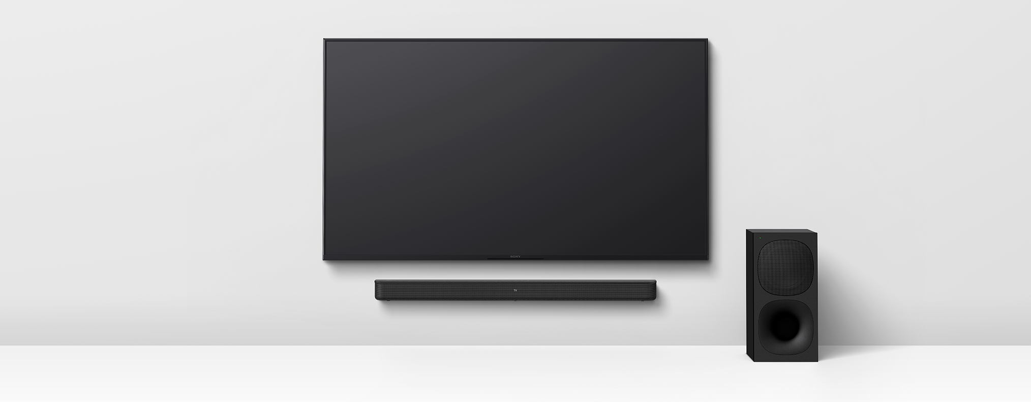 Schwarzer Fernseher, Soundbar und Subwoofer an weißer Wand. Modernes Heimkino.