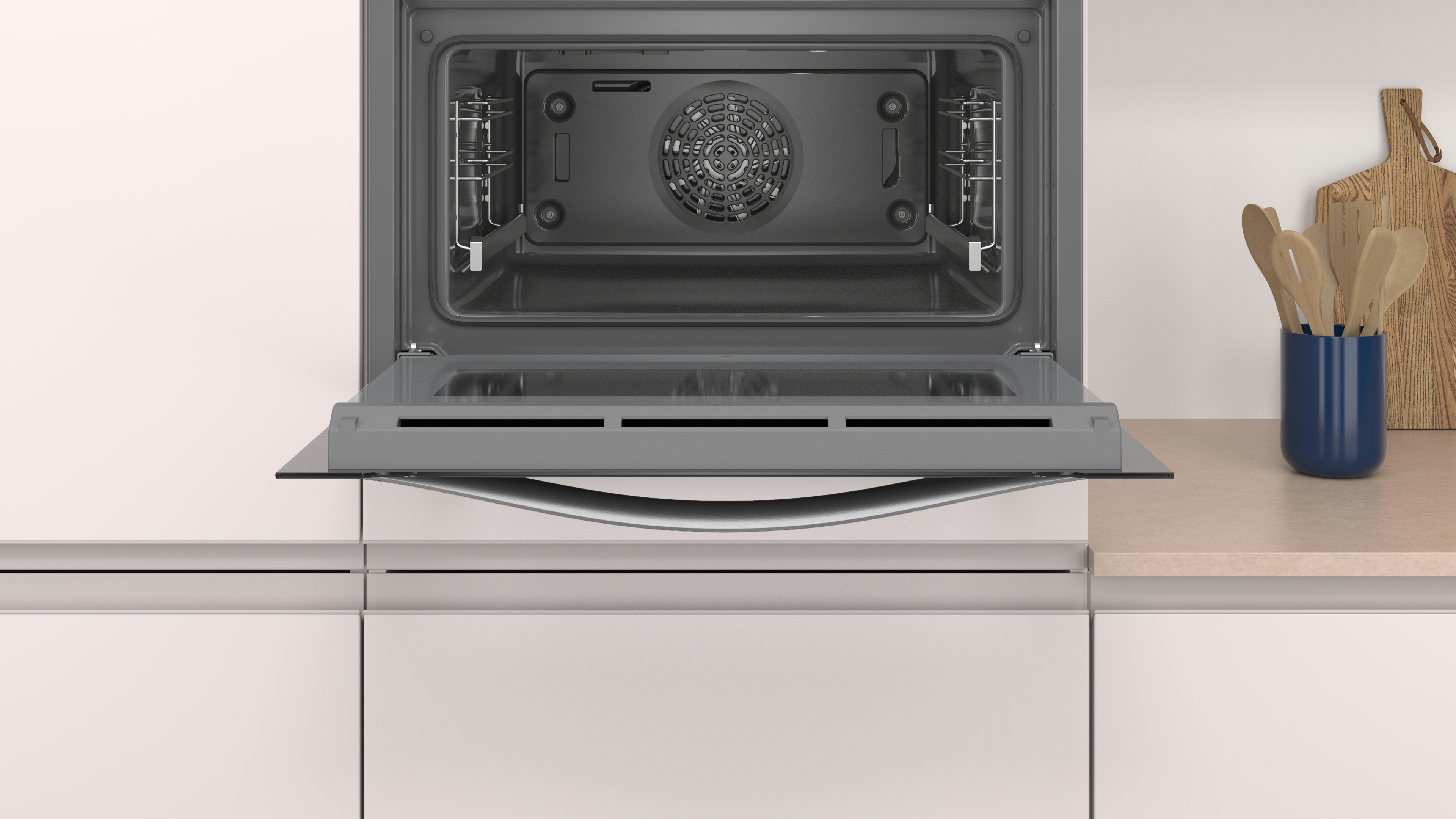 Horno abierto con puerta de cristal. Vista interior con ventilador. Ambiente de cocina blanca.