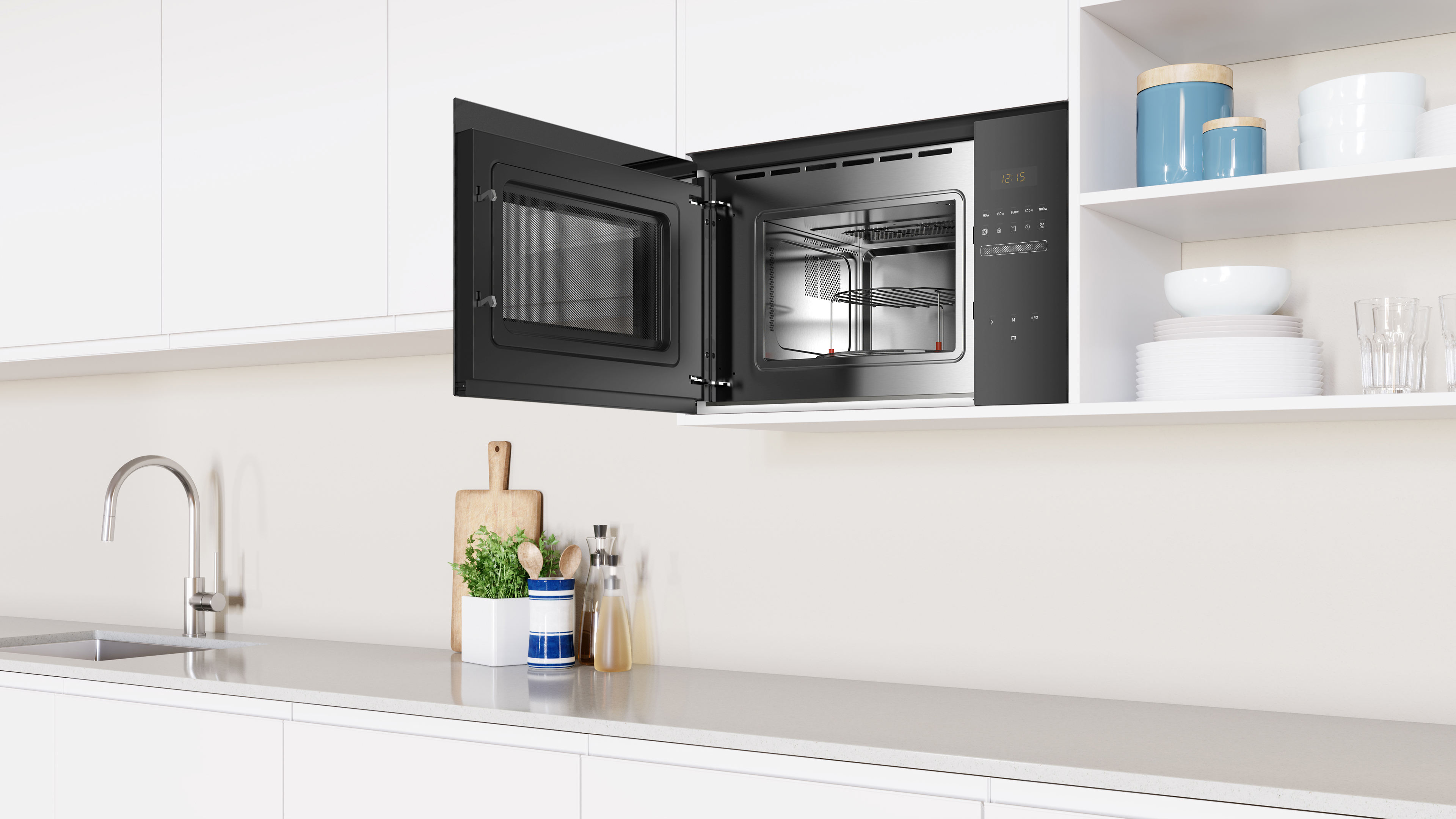 Un horno microondas abierto muestra el interior y el armario de la cocina con puertas blancas.