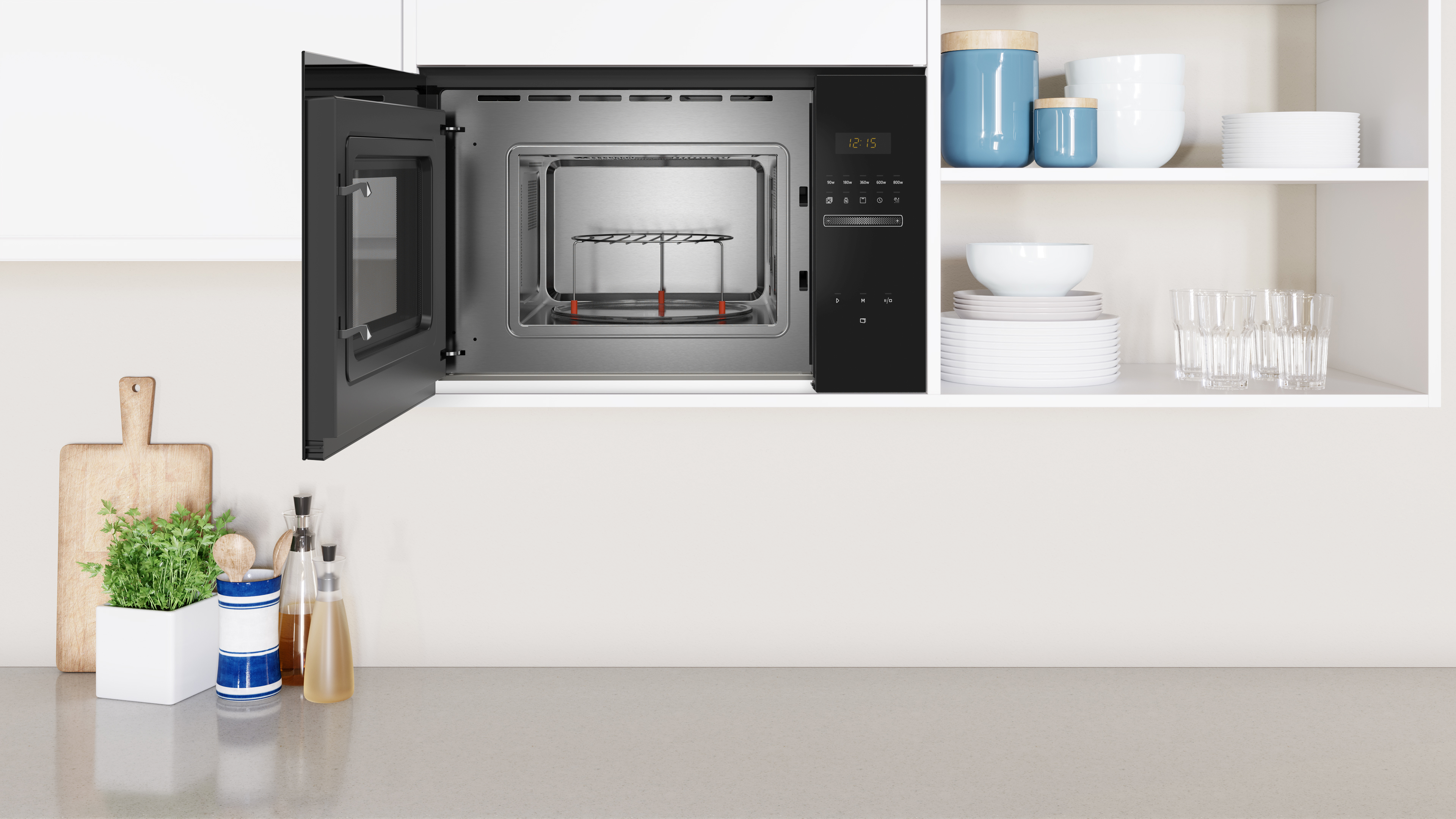 Toma interior de cocina con microondas. Puerta abierta revela interior, con gabinetes y encimera blancos.