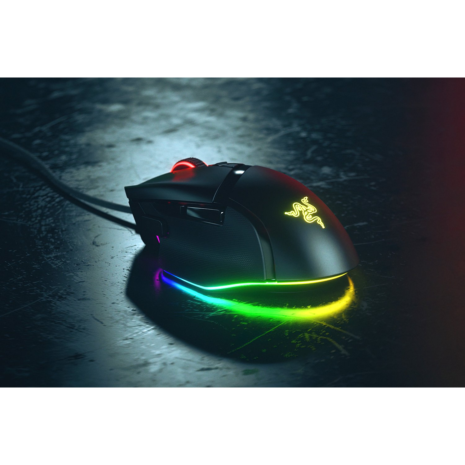 Ratón gaming negro con iluminación LED colorida y logo Razer sobre superficie oscura.